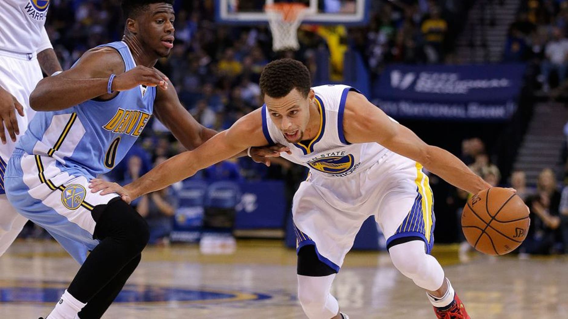Golden State Warriors' Stephen Curry, right, drives the ball against Denver Nuggets' Emmanuel Mudiay during the second half of an NBA basketball game Friday, Nov. 6, 2015, in Oakland, Calif. (AP Photo/Ben Margot)