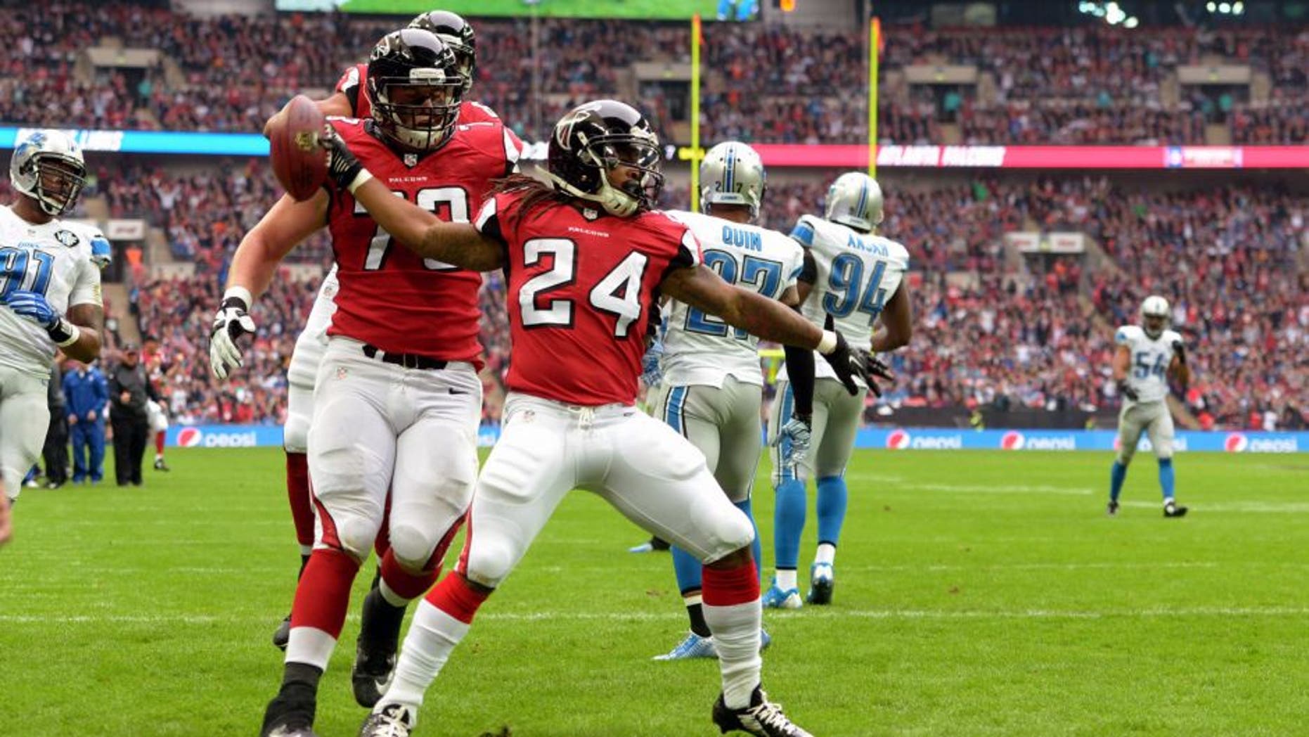 Oct 26, 2014; London, UNITED KINGDOM; Atlanta Falcons running back Devonta Freeman (24) spikes the ball after scoring on a seven-yard touchdown pass in the first quarter against the Detroit Lions as Falcons tackle Ryan Schrader (73) watches in the NFL International Series game at Wembley Stadium. Mandatory Credit: Kirby Lee-USA TODAY Sports