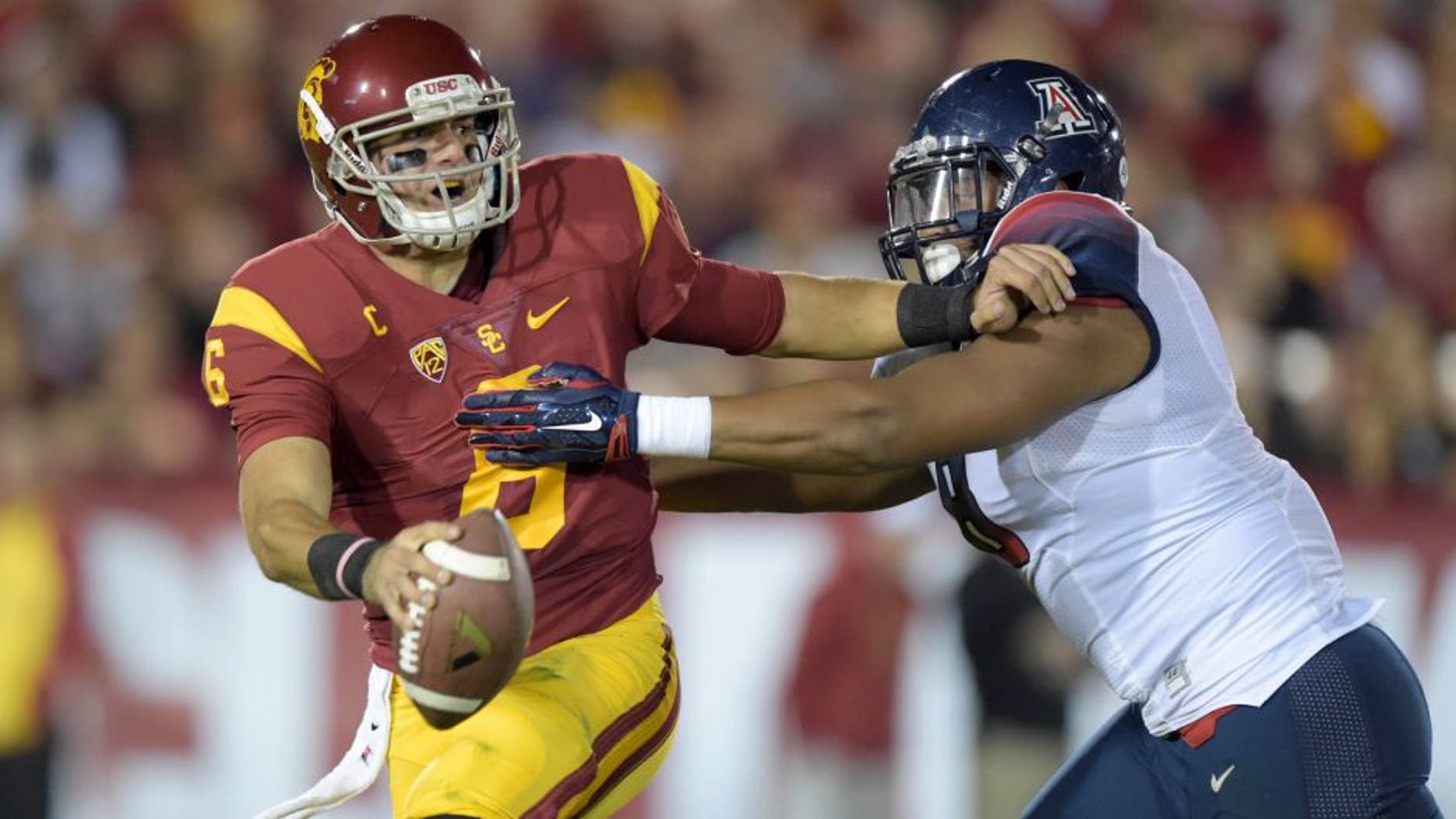 Nov 7, 2015; Los Angeles, CA, USA; Southern California Trojans quarterback Cody Kessler (6) is pressured by Arizona Wildcats defensive end Reggie Gilbert (8) at Los Angeles Memorial Coliseum. Mandatory Credit: Kirby Lee-USA TODAY Sports