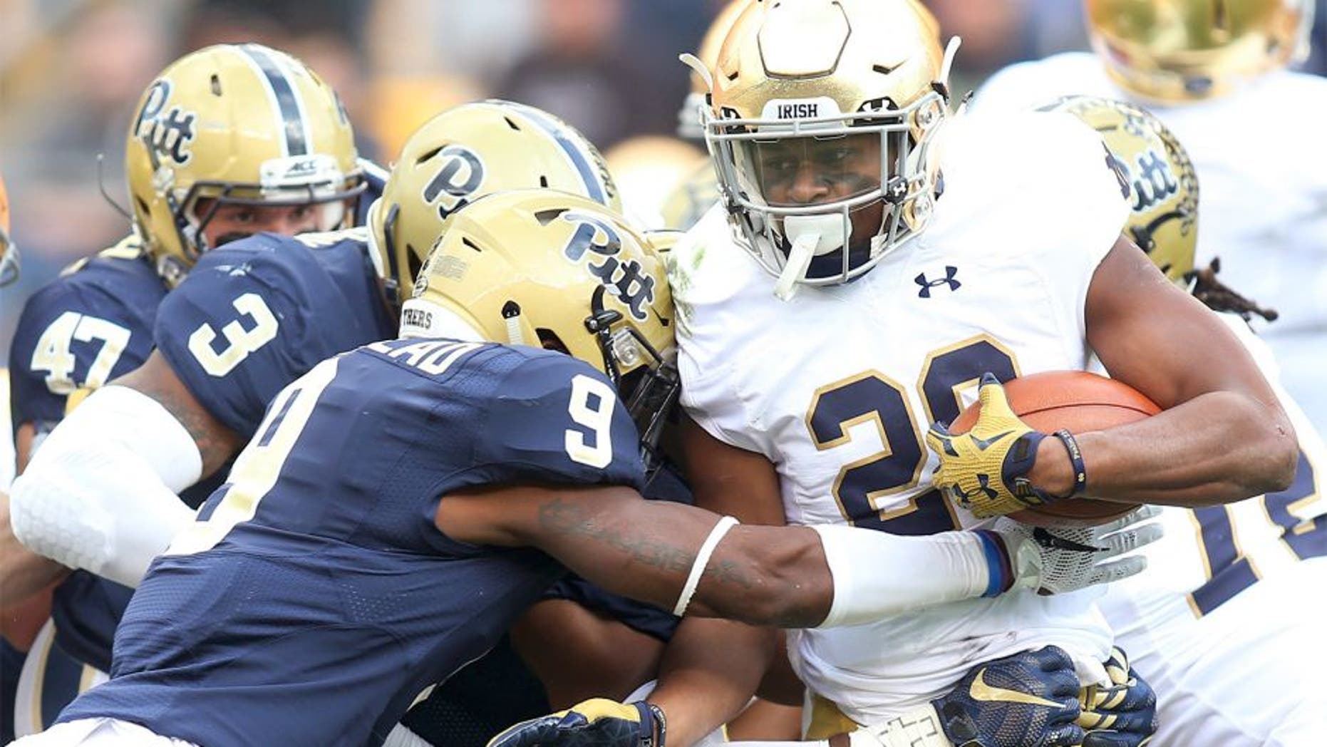 Nov 7, 2015; Pittsburgh, PA, USA; Notre Dame Fighting Irish running back C.J. Prosise (20) carries the ball as Pittsburgh Panthers linebacker Nicholas Grigsby (3) and defensive back Jordan Whitehead (9) defend during the first quarter at Heinz Field. Mandatory Credit: Charles LeClaire-USA TODAY Sports