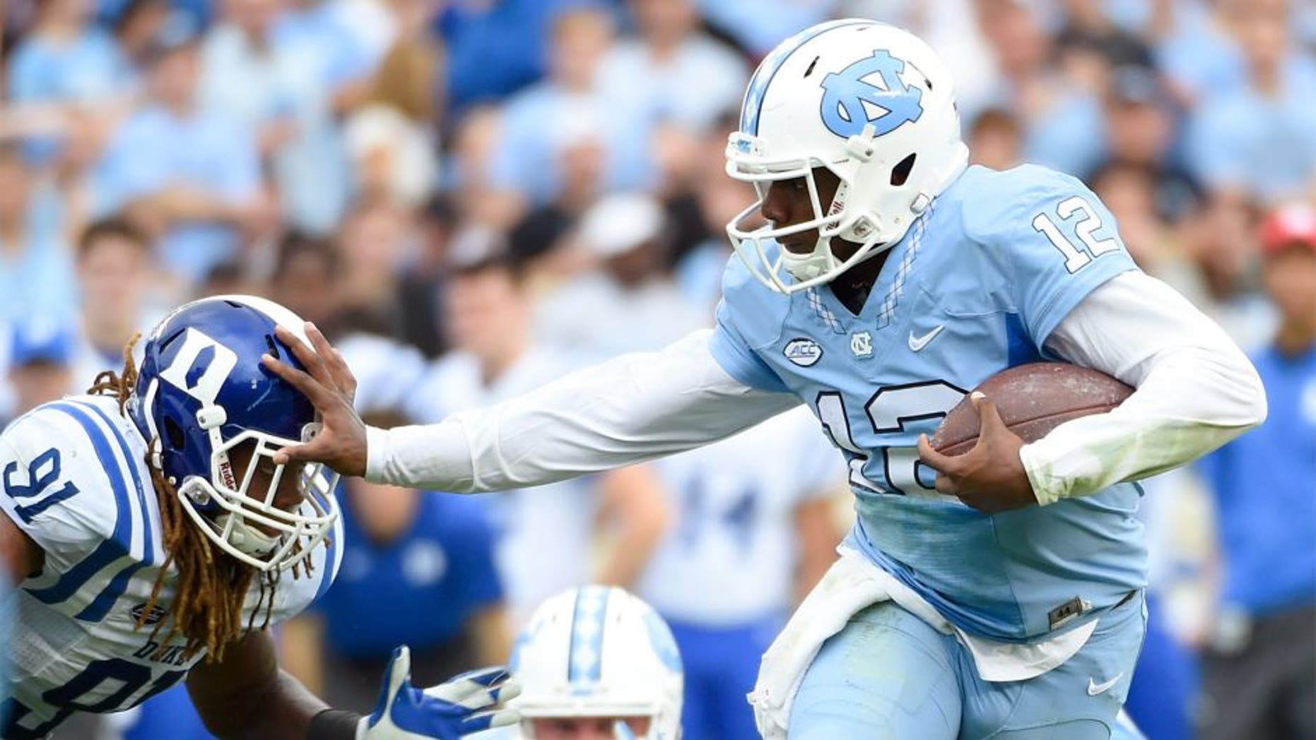 Nov 7, 2015; Chapel Hill, NC, USA; North Carolina Tar Heels quarterback Marquise Williams (12) runs as Duke Blue Devils defensive end Marquies Price (91) defends in the second quarter at Kenan Memorial Stadium. Mandatory Credit: Bob Donnan-USA TODAY Sports