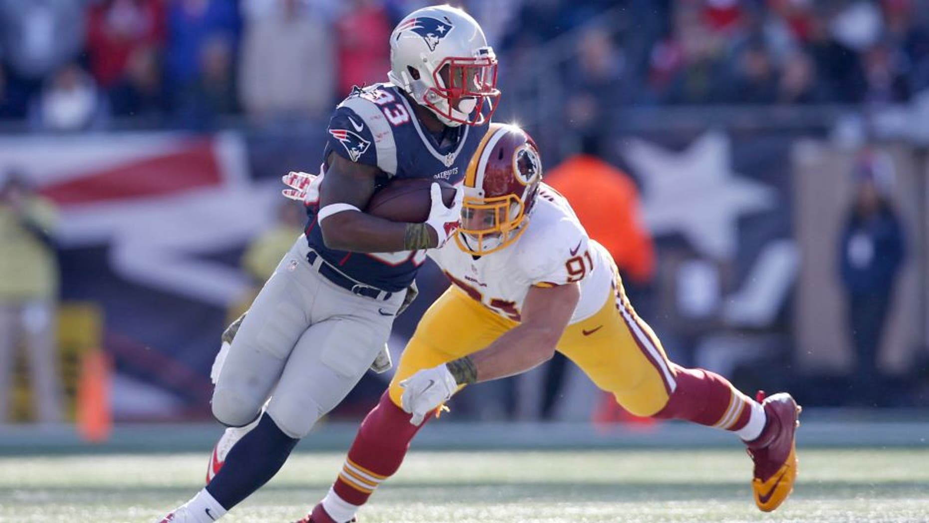 Nov 8, 2015; Foxborough, MA, USA; New England Patriots running back Dion Lewis (33) is tackled by Washington Redskins outside linebacker Ryan Kerrigan (91) during the first quarter at Gillette Stadium. Mandatory Credit: Greg M. Cooper-USA TODAY Sports