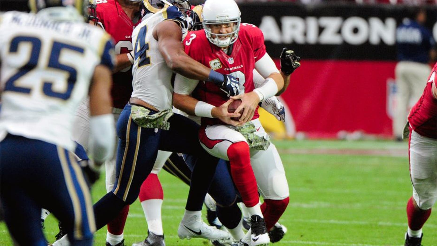 Nov 9, 2014; Glendale, AZ, USA; Arizona Cardinals quarterback Carson Palmer (3) is sacked by St. Louis Rams defensive end Robert Quinn (94) and defensive tackle Aaron Donald (99) during the first half at University of Phoenix Stadium. Mandatory Credit: Matt Kartozian-USA TODAY Sports