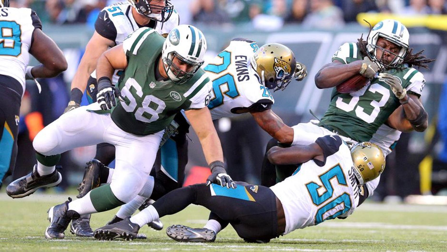 Nov 8, 2015; East Rutherford, NJ, USA; New York Jets running back Chris Ivory (33) runs the ball against Jacksonville Jaguars free safety Josh Evans (26) and Jacksonville Jaguars outside linebacker Telvin Smith (50) during the fourth quarter at MetLife Stadium. Mandatory Credit: Brad Penner-USA TODAY Sports