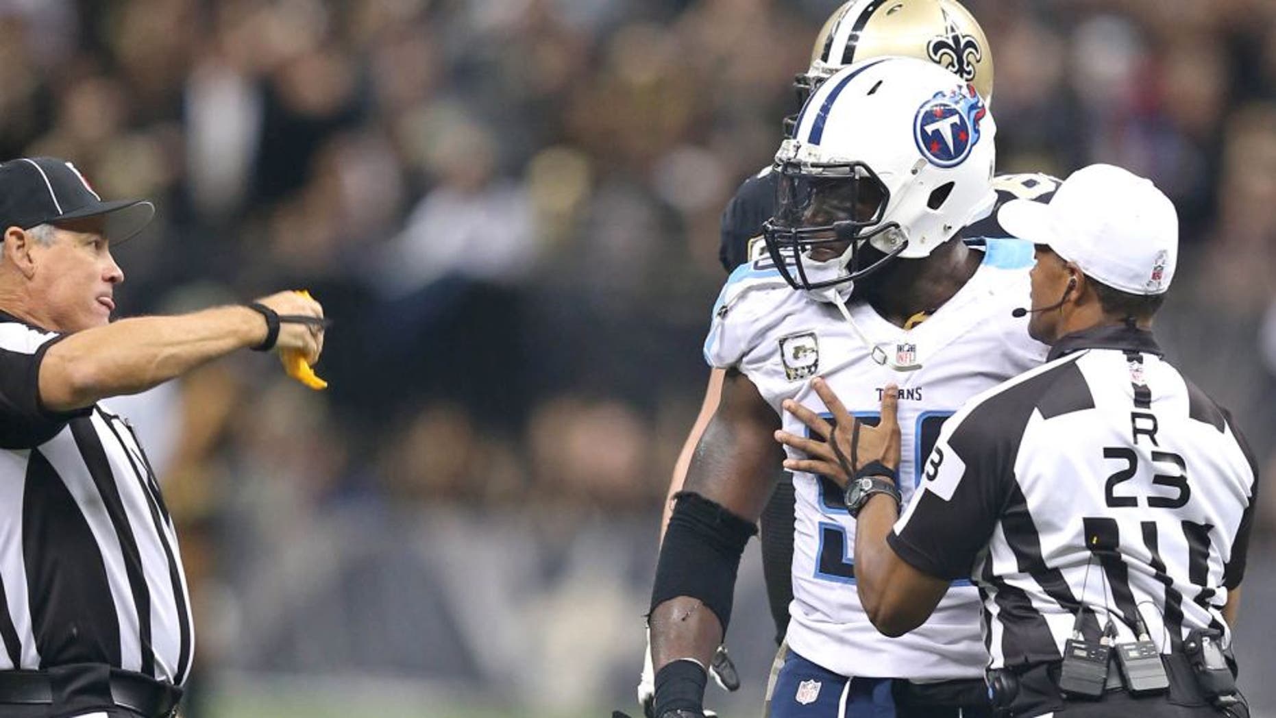 Nov 8, 2015; New Orleans, LA, USA; Tennessee Titans outside linebacker Brian Orakpo (98) is held back by referee Jerome Boger (23) while line judge Jeff Seeman throws a flag in the second half of their game against the New Orleans Saints at the Mercedes-Benz Superdome. The Titans won, 34-28, in overtime. Mandatory Credit: Chuck Cook-USA TODAY Sports