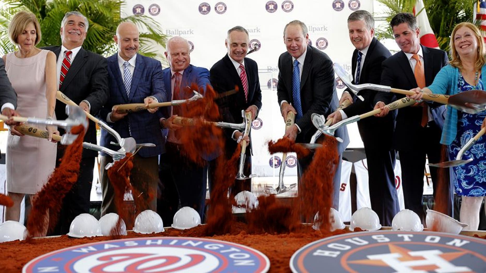 Major League Baseball commissioner Rob Manfred, center left, is flanked by Houston Astros owner Jim Crane, right center, and Washington Nationals owner Mark Lerner, left center, along with other dignitaries during a groundbreaking ceremony for the future home of the of Houston Astros and the Washington Nationals spring training facility on Monday, Nov. 9, 2015, in West Palm Beach, Fla. (AP Photo/Steve Mitchell)