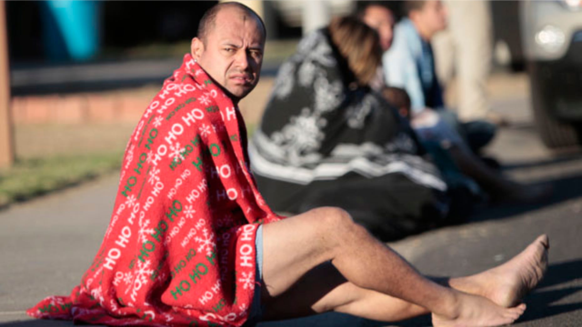 Nov. 10: Mark Rodriguez-Banks sits on the ground during a raid in Phoenix.