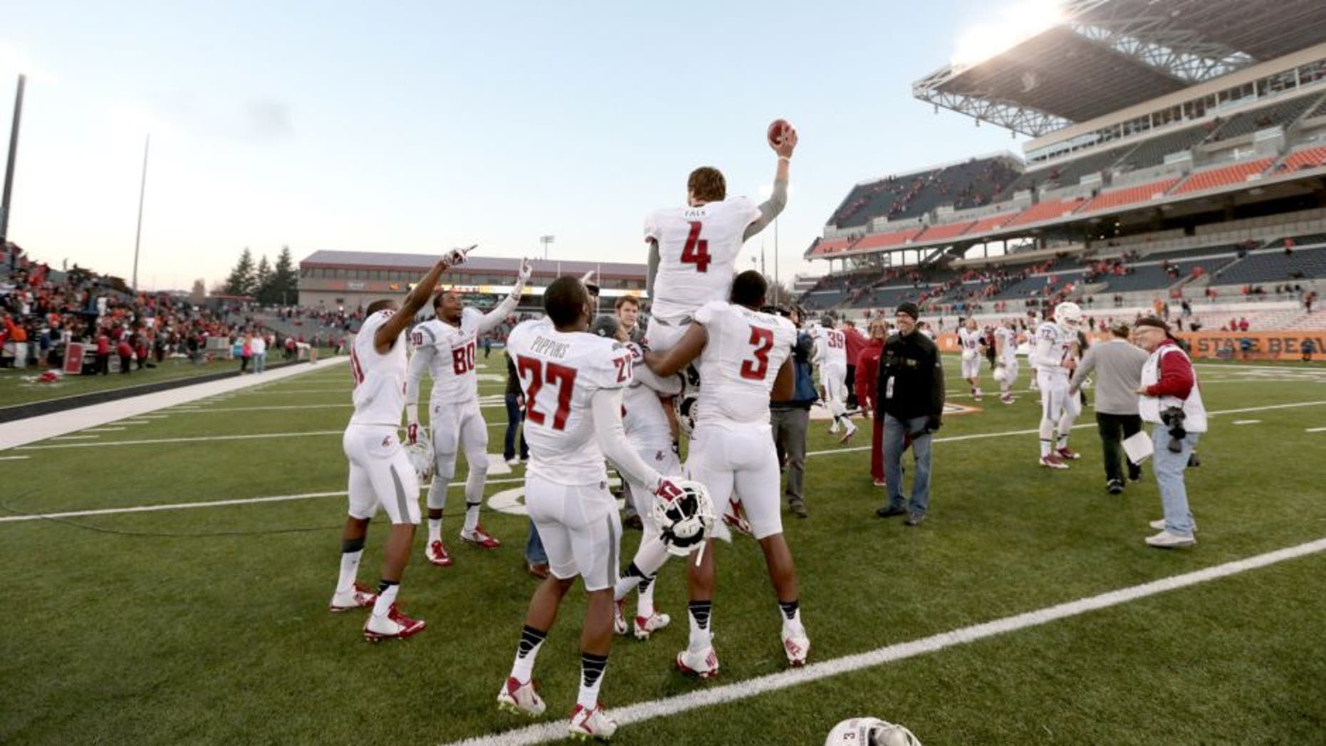 Nov 8, 2014; Corvallis, OR, USA; Washington State Cougars quarterback Luke Falk (4) is lifted into the air by linebacker Ivan McLennan (3) and wide receiver Rickey Galvin (5) following a win against the Oregon State Beavers against the Oregon State Beavers at Reser Stadium. Mandatory Credit: Scott Olmos-USA TODAY Sports