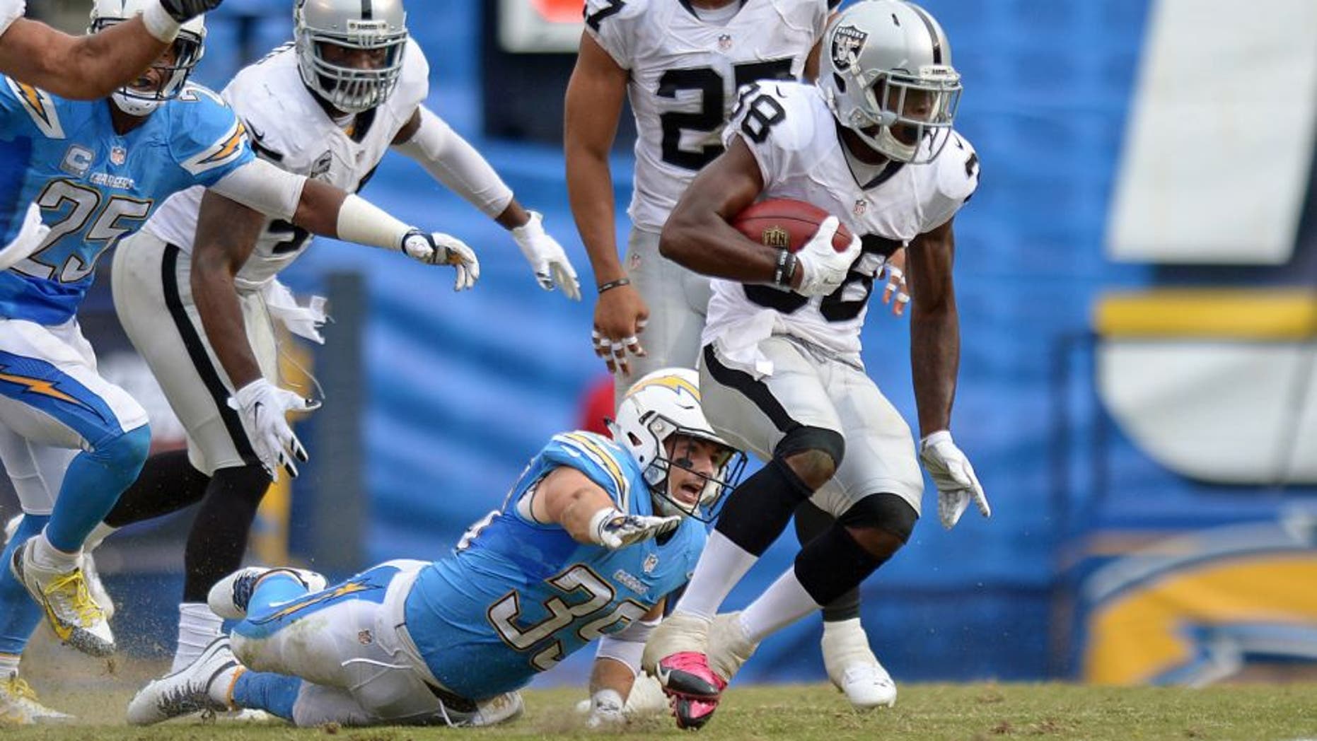 Oct 25, 2015; San Diego, CA, USA; Oakland Raiders strong safety T.J. Carrie (38) returns a punt as San Diego Chargers running back Danny Woodhead (39) defends during the third quarter at Qualcomm Stadium. Mandatory Credit: Jake Roth-USA TODAY Sports