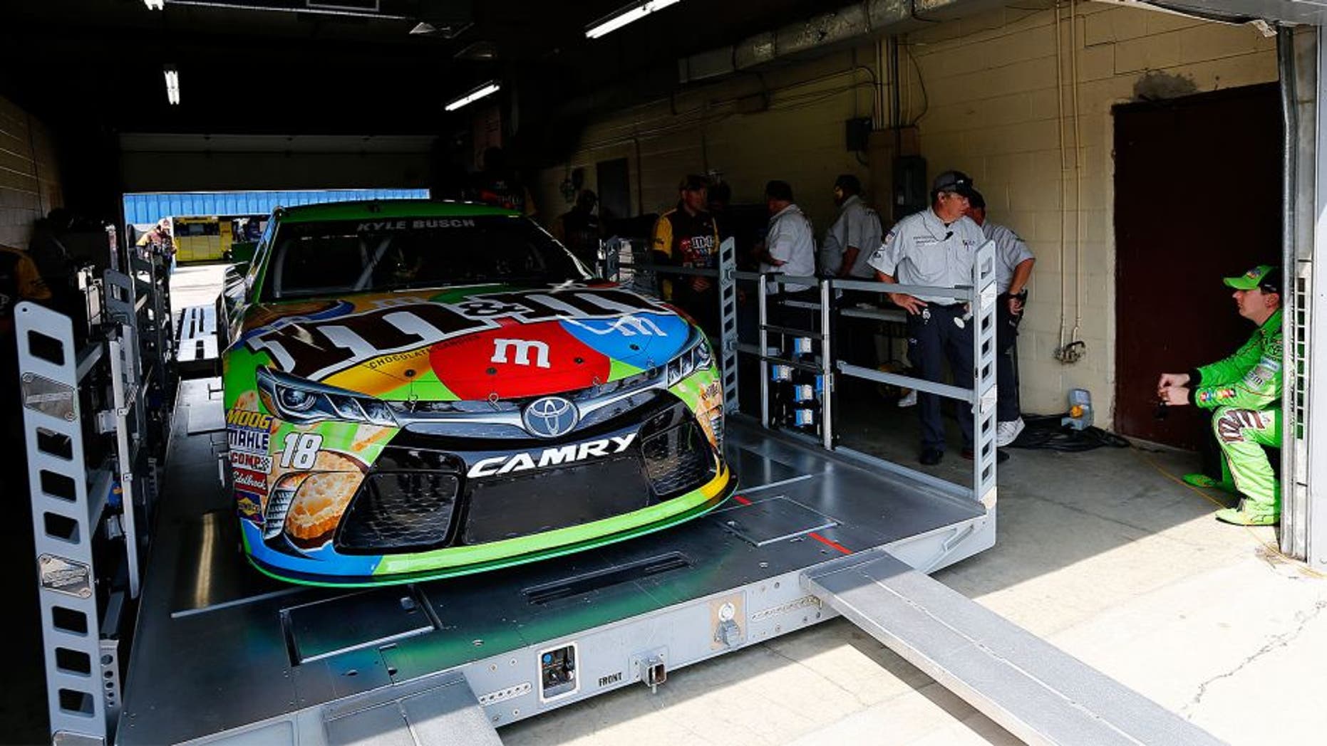 BROOKLYN, MI - JUNE 12: Kyle Busch, driver of the #18 M&M's Crispy Toyota, waits as his car goes through technical inspection prior to qualifying for the NASCAR Sprint Cup Series Quicken Loans 400 at Michigan International Speedway on June 12, 2015 in Brooklyn, Michigan. (Photo by Jonathan Ferrey/NASCAR via Getty Images)