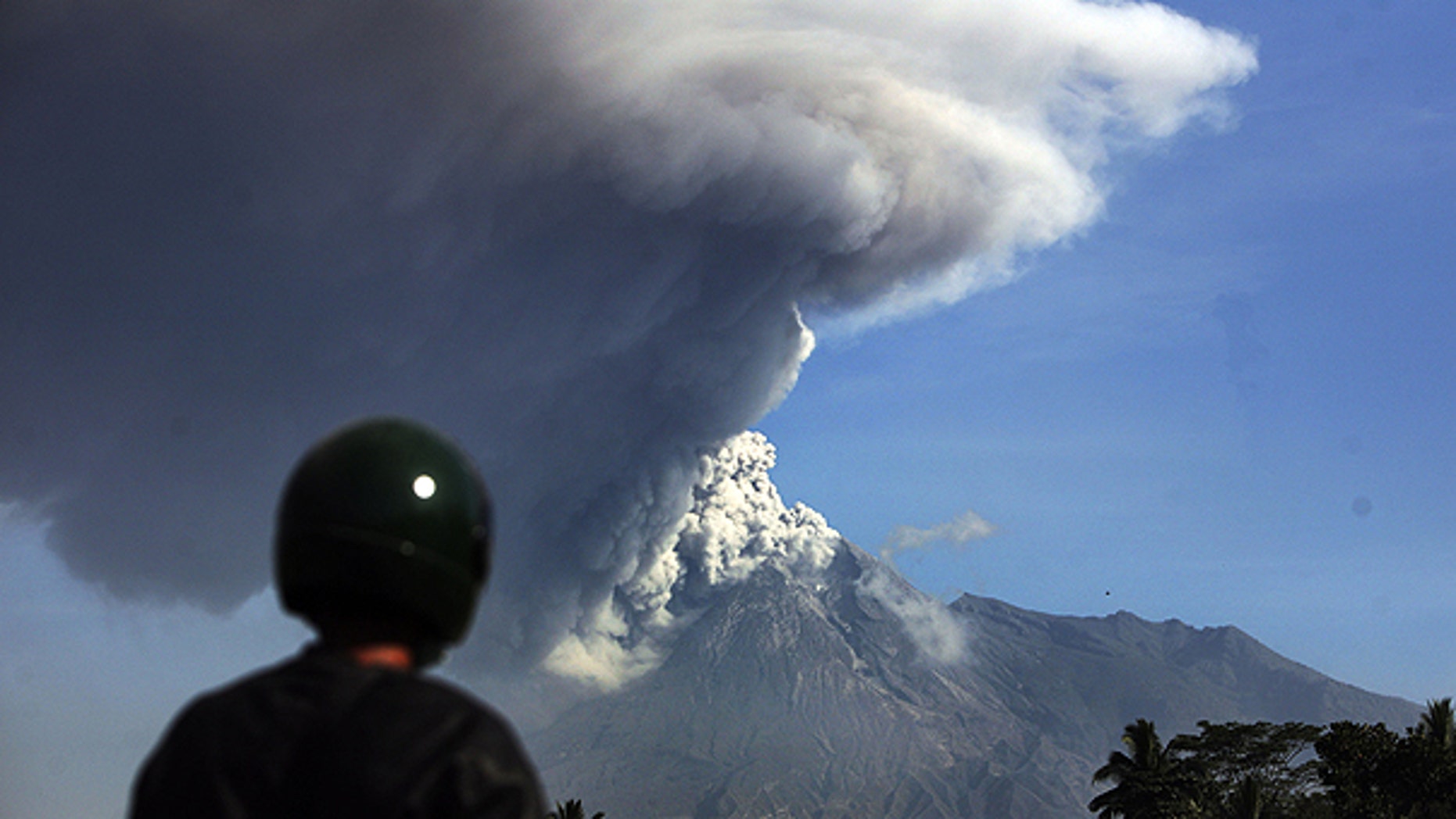 Nov. 12: A man watches Mount Merapi spews volcanic material as seen from Argomulyo, Indonesia.