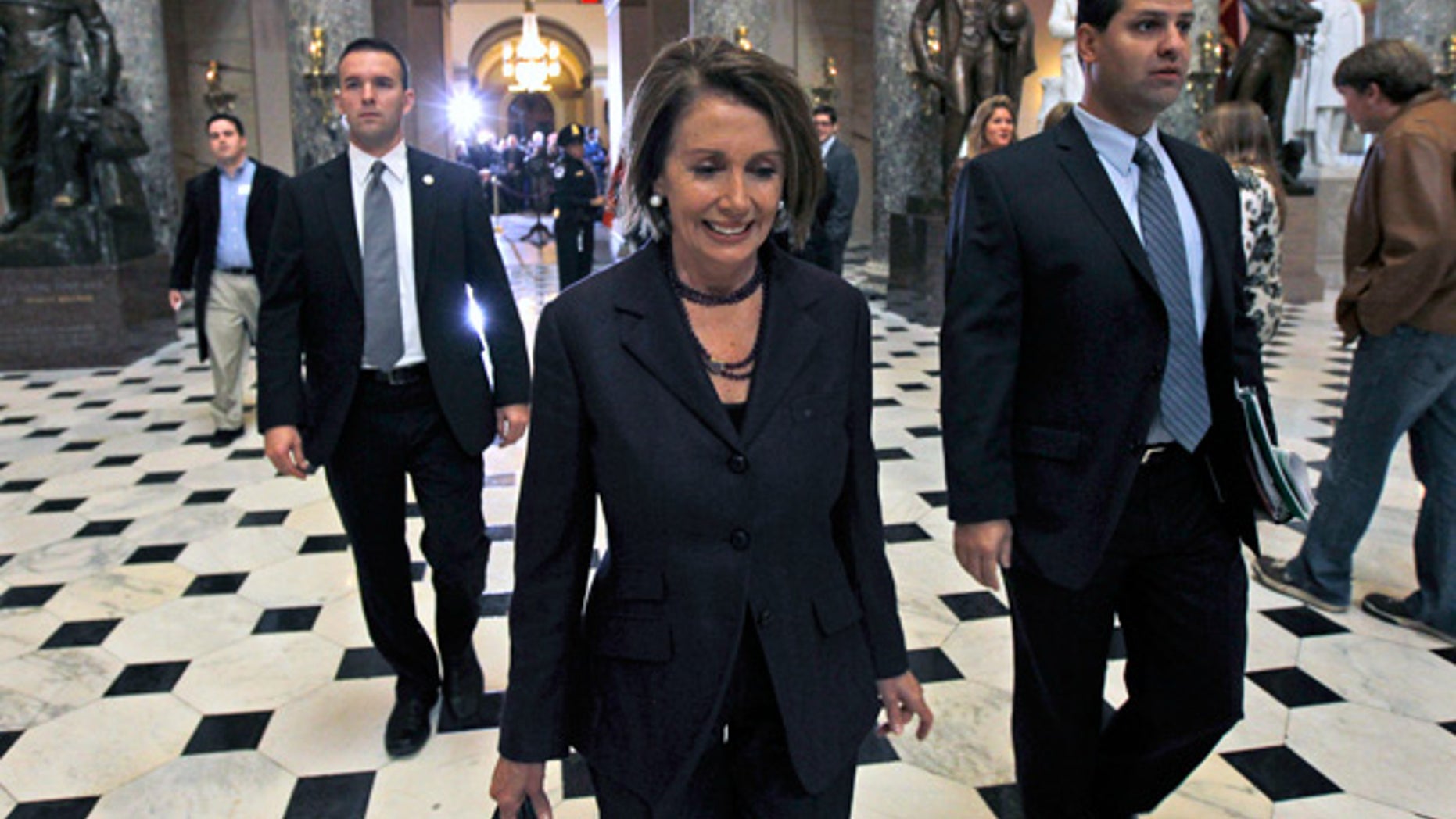 Nov. 10: House Speaker Nancy Pelosi walks past the set up for a news conference for House Speaker-in-waiting John Boehner.
