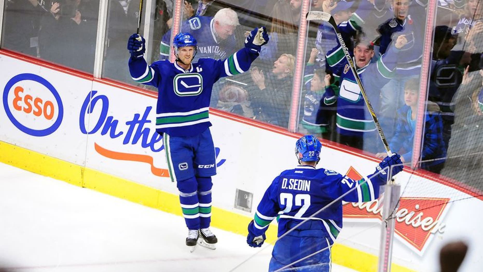 Nov 11, 2014; Vancouver, British Columbia, CAN; Vancouver Canucks forward Henrik Sedin (33) celebrates with forward Daniel Sedin (22) for a goal against Ottawa Senators goaltender Craig Anderson (41) (not pictured) during the overtime at Rogers Arena. The Vancouver Canucks won 4-3 in overtime. Mandatory Credit: Anne-Marie Sorvin-USA TODAY Sports