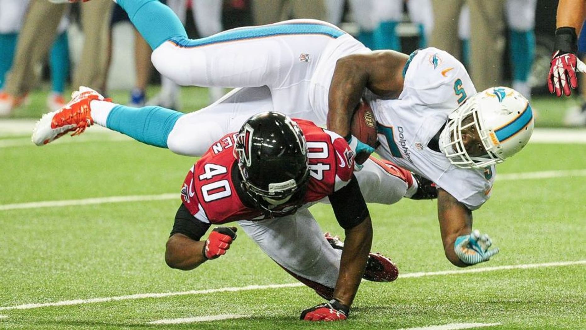 ATLANTA, GA - AUGUST 08: Damien Williams #5 of the Miami Dolphins is tackled by Kimario McFadden #40 of the Atlanta Falcons in the fourth quarter of a preseason game at the Georgia Dome on August 8, 2014 in Atlanta, Georgia. The Falcons won 16-10. (Photo by Scott Cunningham/Getty Images)