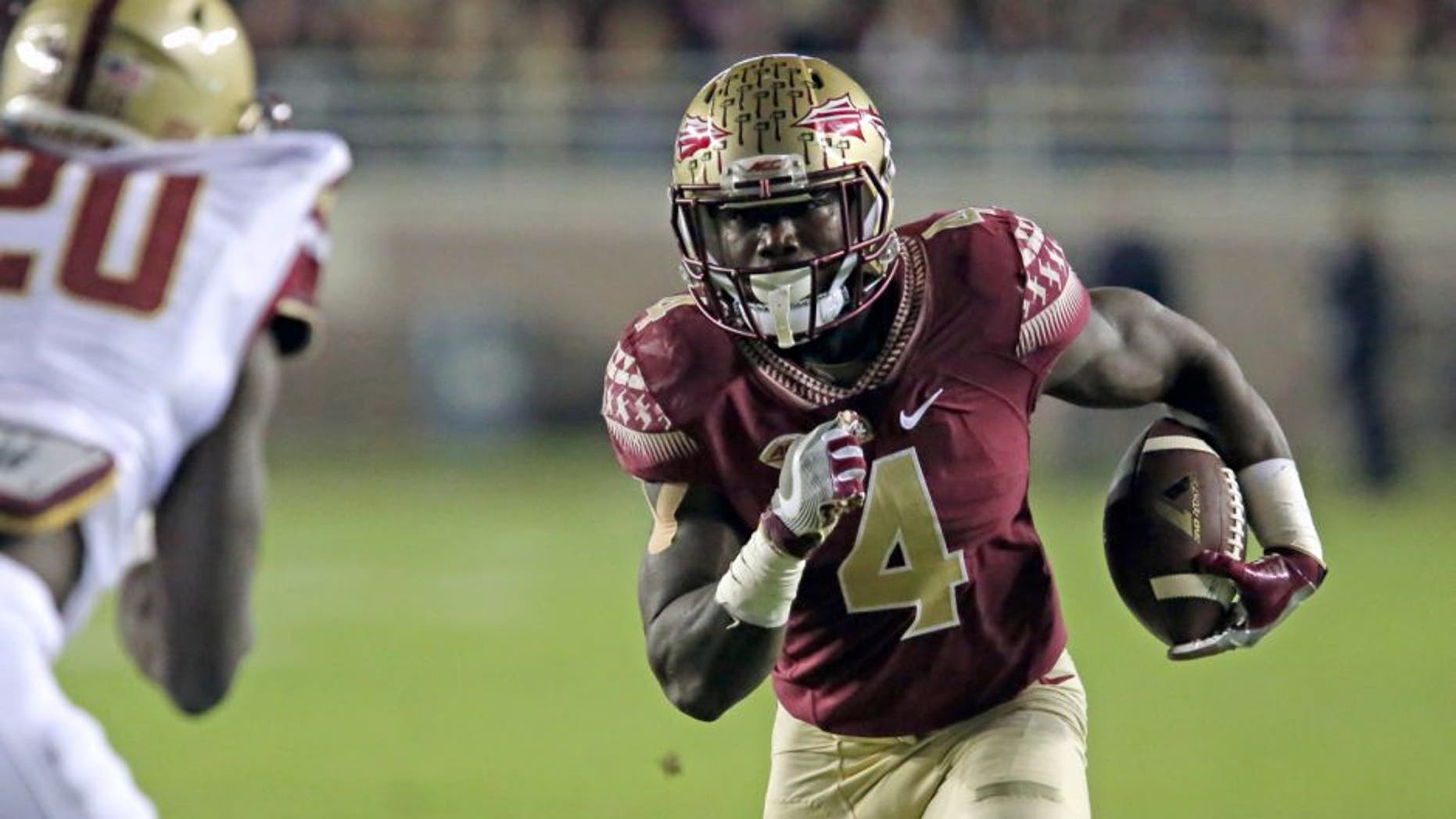 Florida State's Dalvin Cook picks up yardage as Boston College's defender Isaac Yiadom moves in for the tackle in the first half of an NCAA college football game, Friday, Nov. 11, 2016, in Tallahassee, Fla. (AP Photo/Steve Cannon)