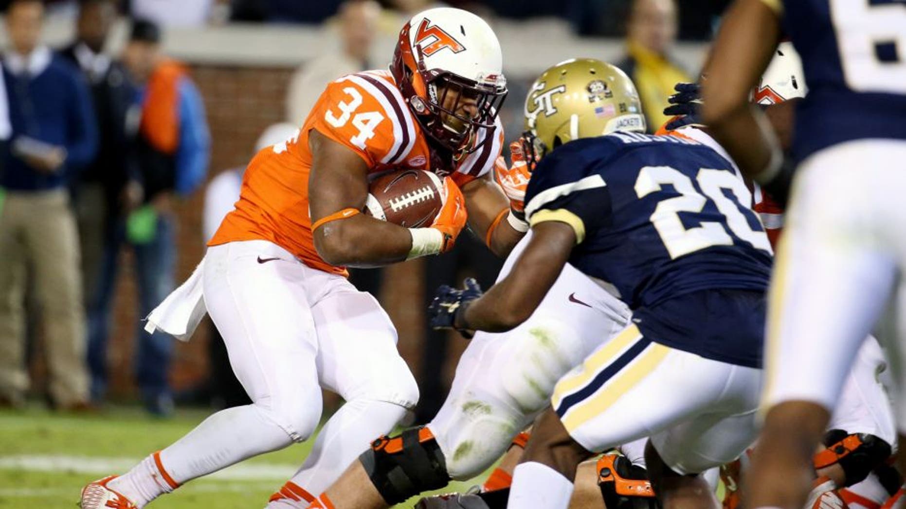 Nov 12, 2015; Atlanta, GA, USA; Virginia Tech Hokies running back Travon McMillian (34) runs against Georgia Tech Yellow Jackets defensive back Lawrence Austin (20) in the second quarter of their game at Bobby Dodd Stadium. Mandatory Credit: Jason Getz-USA TODAY Sports