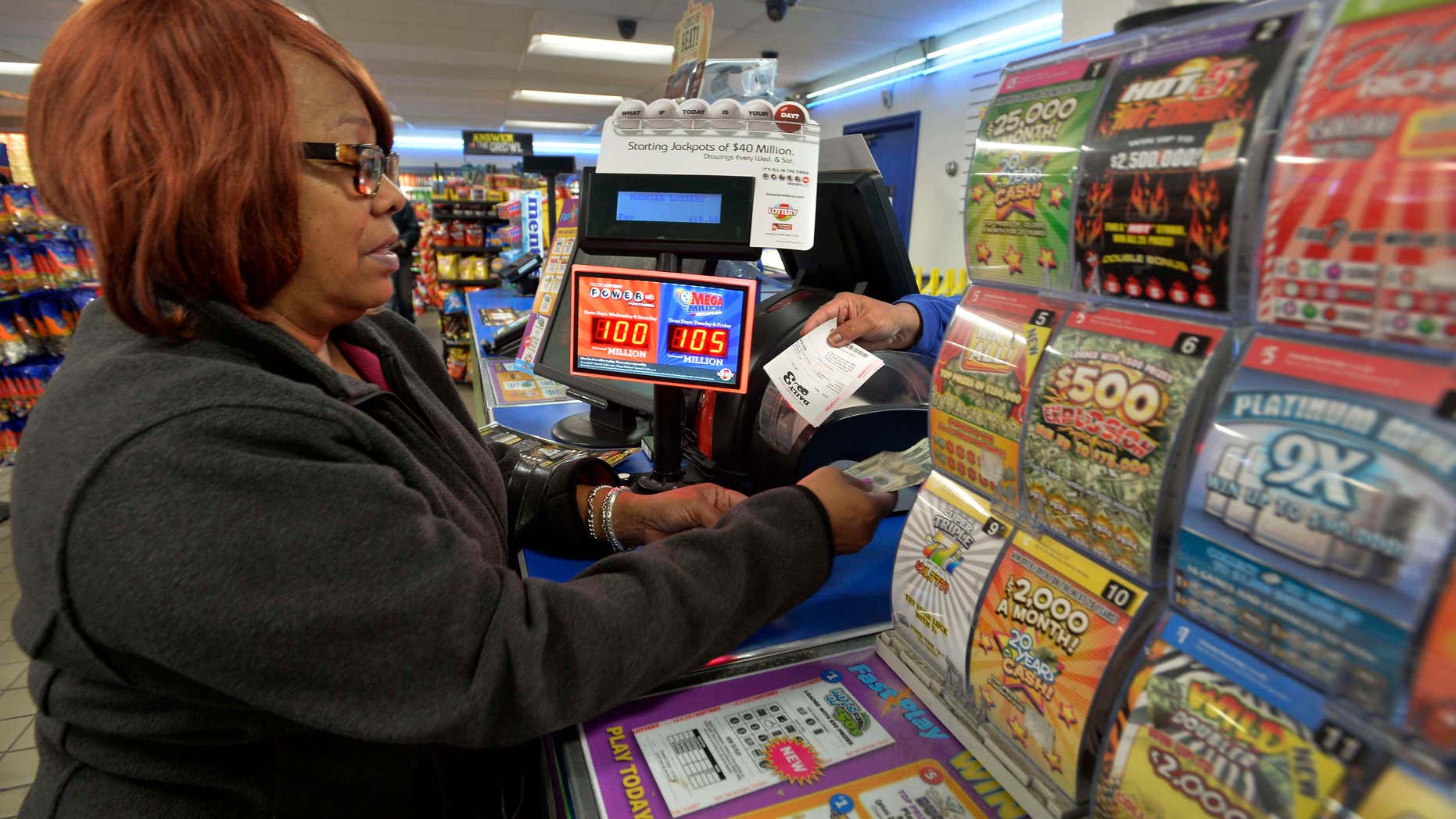 FILE - In this Oct. 23, 2015 file photo, Vera Washington of Chicago, buys lotto tickets at the K&D Marathon station in Hammond, Ind.