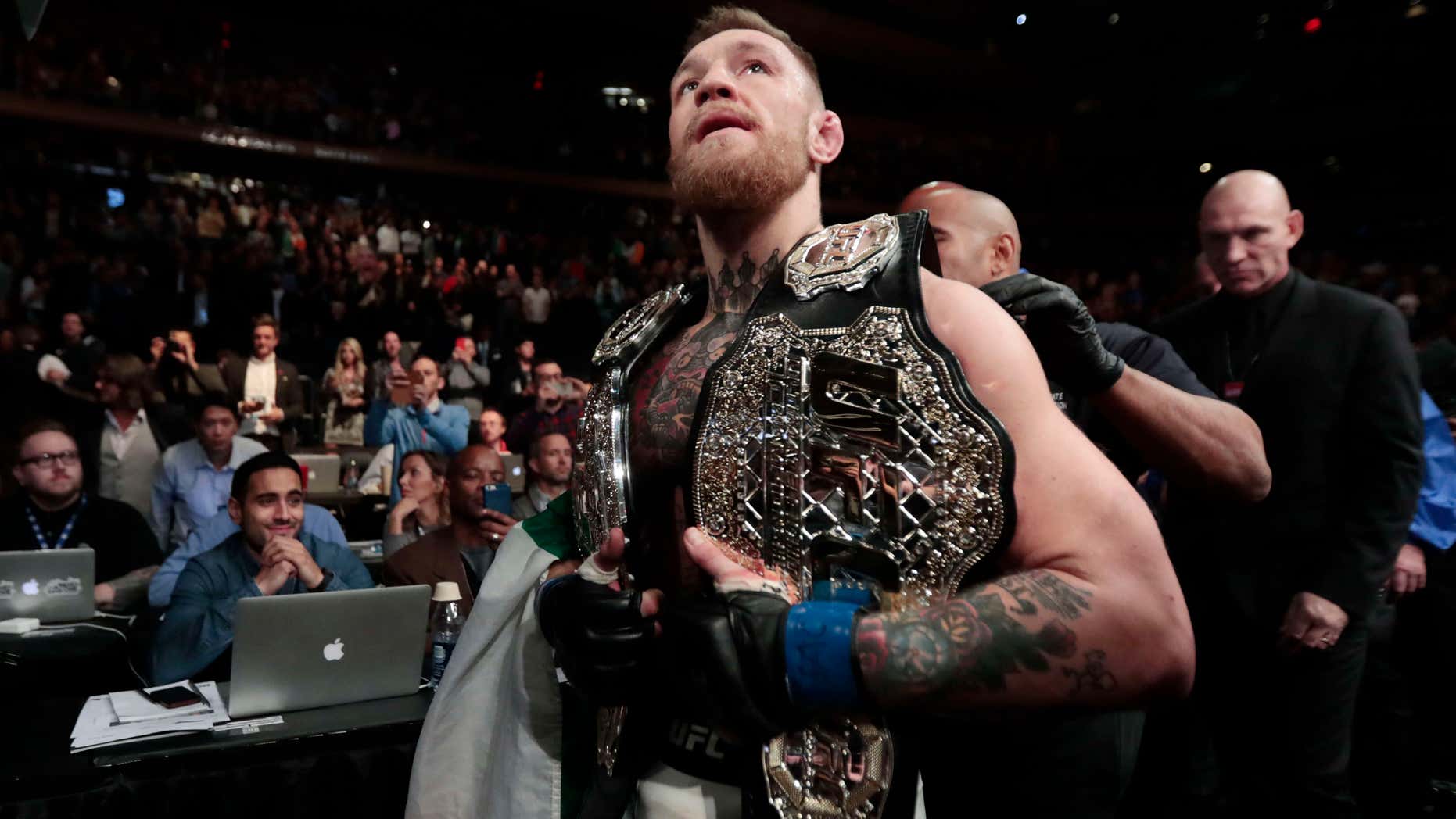 Nov. 13, 2016: Conor McGregor leaves the octagon with his title belts after knocking out Eddie Alvarez during a lightweight mixed martial arts bout at UFC 205.