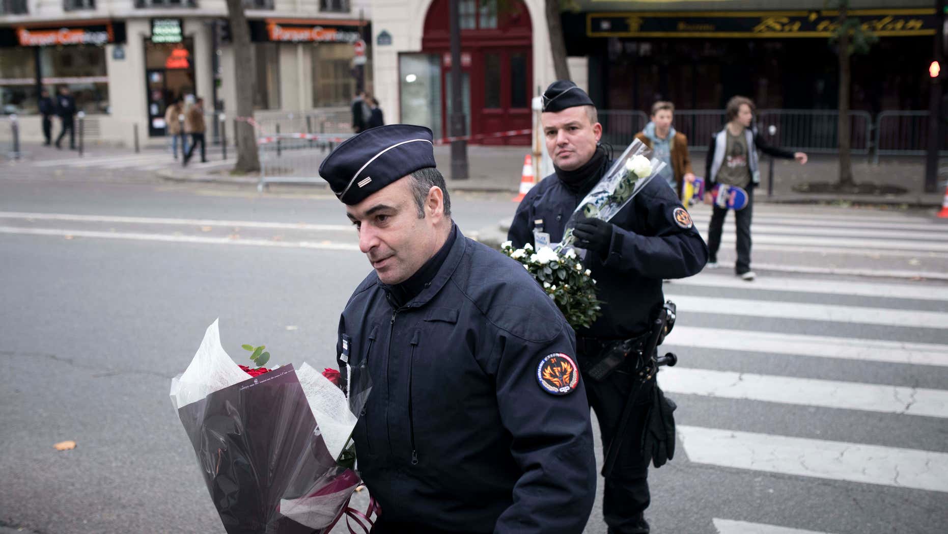 Nov. 12, 2016: Police officers hold flowers, given by people near the Bataclan concert hall in Paris, France.