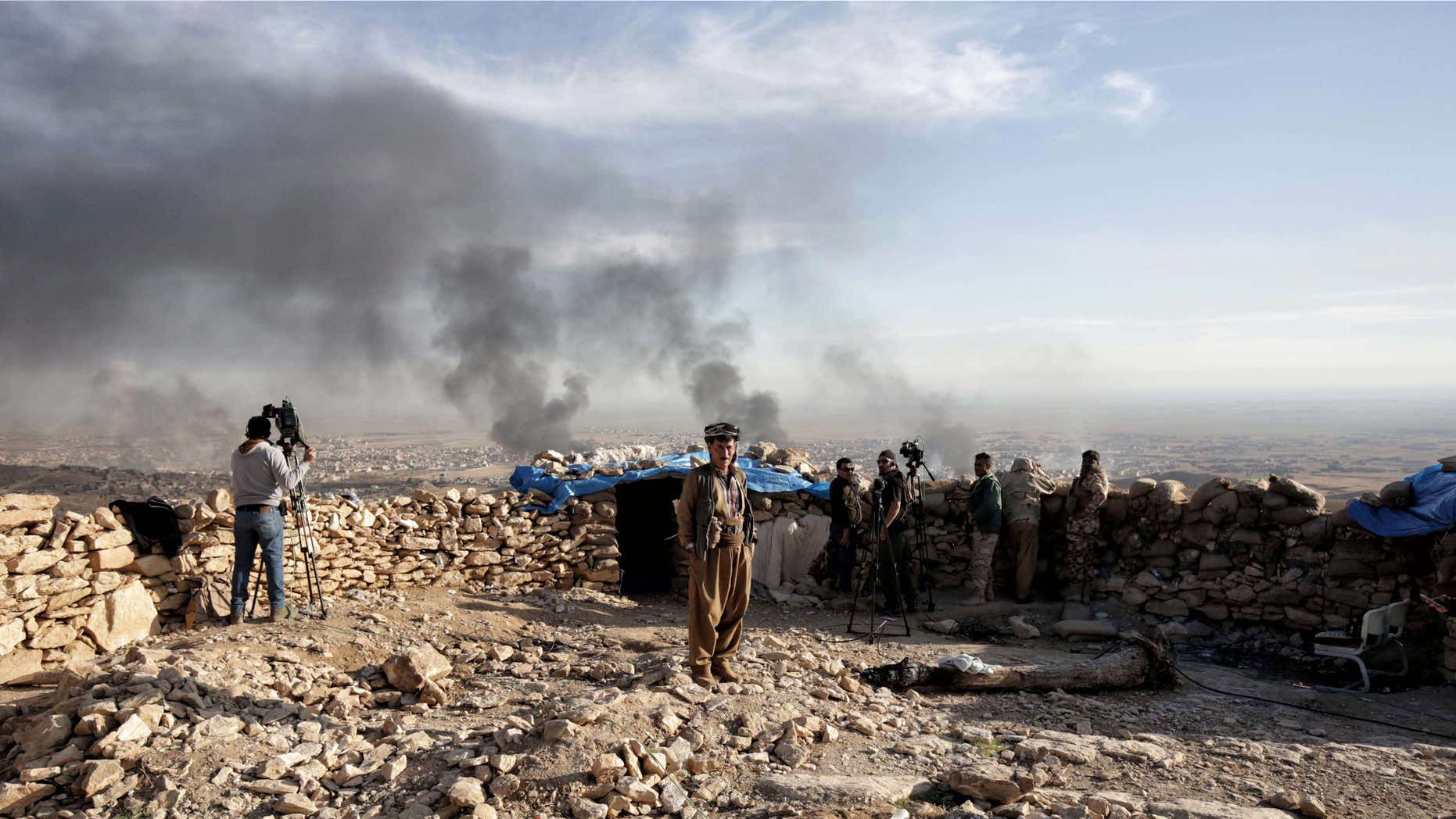 Nov. 12, 2015: Smoke rises over Sinjar, northern Iraq from oil fires set by Islamic State militants as Kurdish Iraqi fighters, backed by U.S.-led airstrikes, launch a major assault.