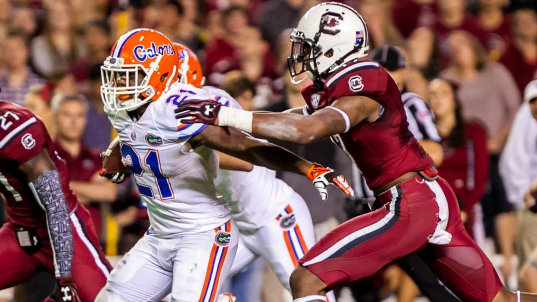 Nov 16, 2013; Columbia, SC, USA; Florida Gators running back Kelvin Taylor (21) breaks the tackle of South Carolina Gamecocks safety Chaz Elder (17) on the way to a touchdown in the second quarter at Williams-Brice Stadium. Mandatory Credit: Jeff Blake-USA TODAY Sports