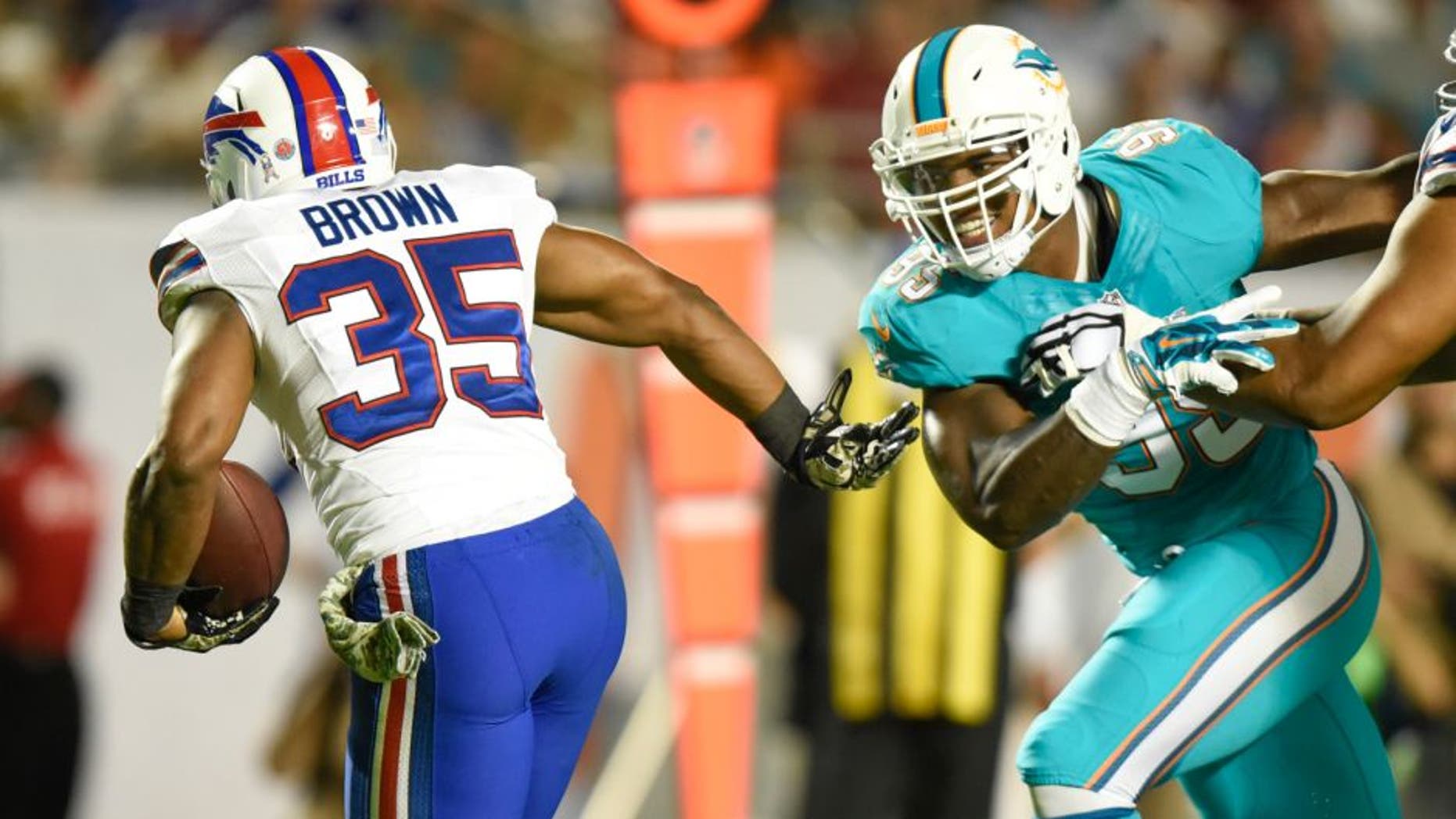 Nov 13, 2014; Miami Gardens, FL, USA; Miami Dolphins long snapper John Denney (92) tries to tackle Buffalo Bills running back Bryce Brown (35) in the first half of the game at Sun Life Stadium. Mandatory Credit: Brad Barr-USA TODAY Sports
