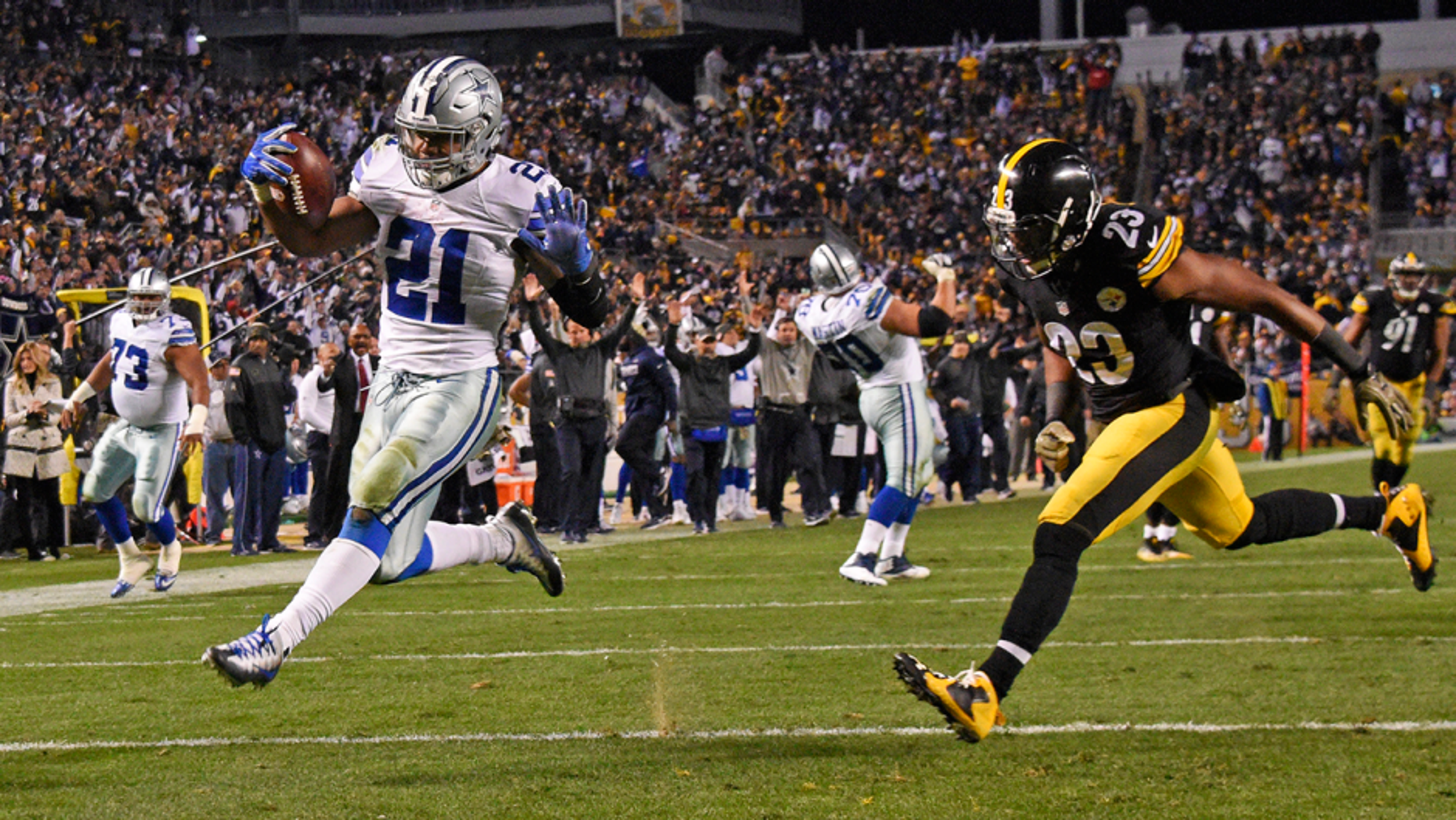 Dallas Cowboys running back Ezekiel Elliott (21) rushes for a touchdown with Pittsburgh Steelers free safety Mike Mitchell (23) defending during the second half of an NFL football game in Pittsburgh, Sunday, Nov. 13, 2016. (AP Photo/Don Wright)