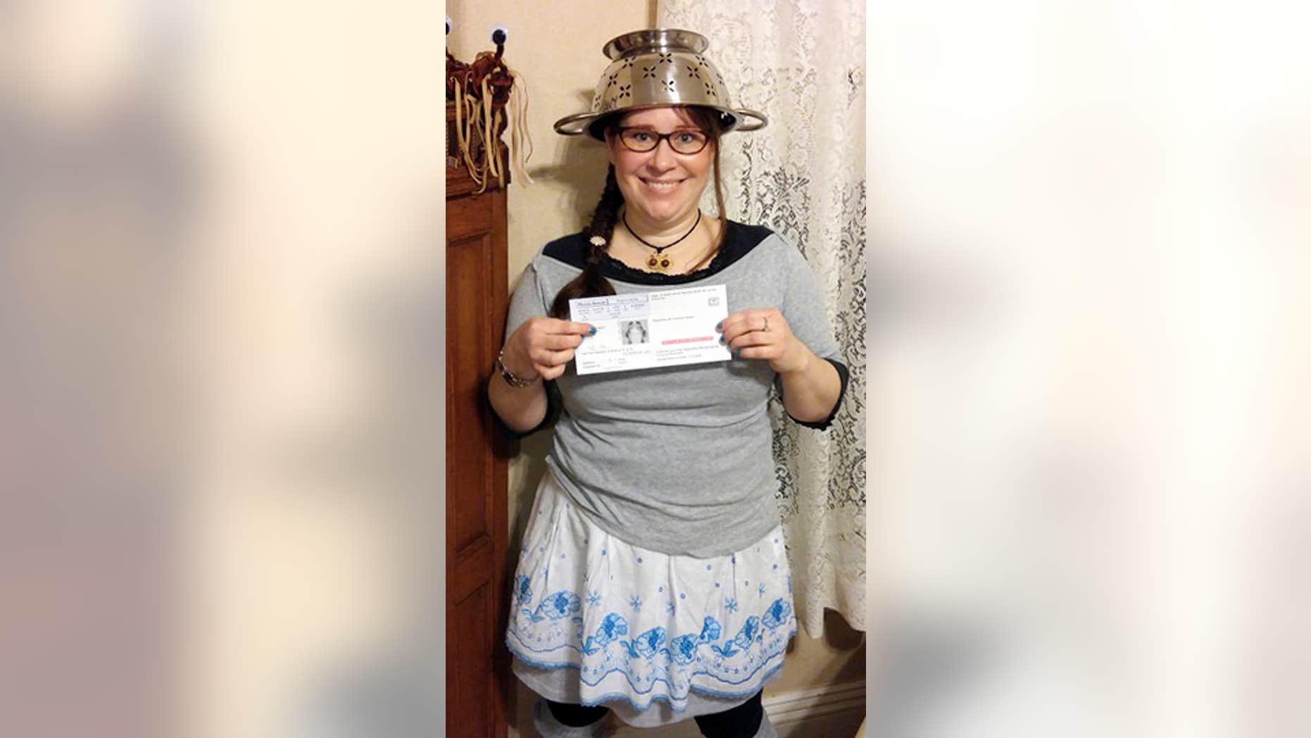 In this Nov. 12, 2015 photo provided by Darrick Fauvel, Lindsay Miller of Lowell, Mass., wears a spaghetti strainer to reflect her religious beliefs while holding her temporary driver license that also bears a photo of her wearing the colander.