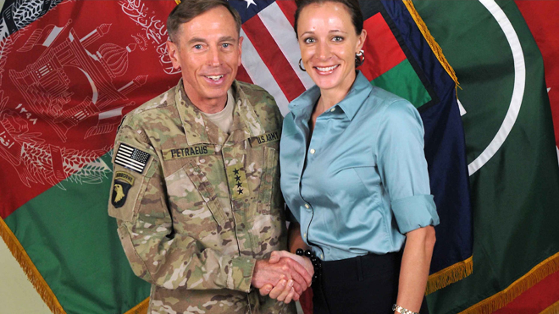 July 13, 2011: Former Commander of International Security Assistance Force and U.S. Forces-Afghanistan Gen. Davis Petraeus, left, shakes hands with Paula Broadwell, co-author of his biography "All In: The Education of General David Petraeus." (AP/ISAF)