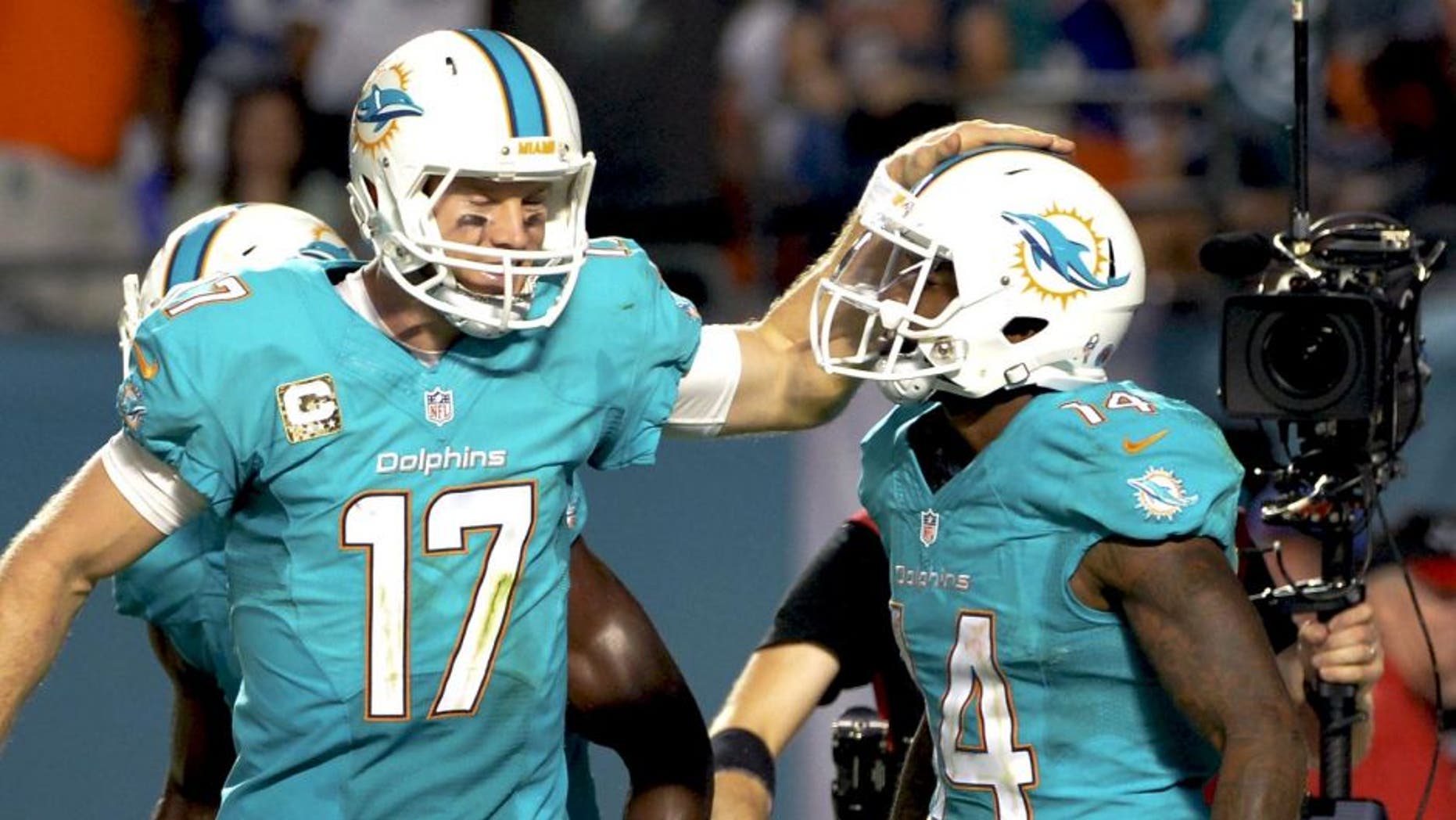 Nov 13, 2014; Miami Gardens, FL, USA; Miami Dolphins quarterback Ryan Tannehill (left) celebrates after wide receiver Jarvis Landry (right) scored a touchdown against the Buffalo Bills during the second half at Sun Life Stadium. The Dolphins won 22-9. Mandatory Credit: Steve Mitchell-USA TODAY Sports