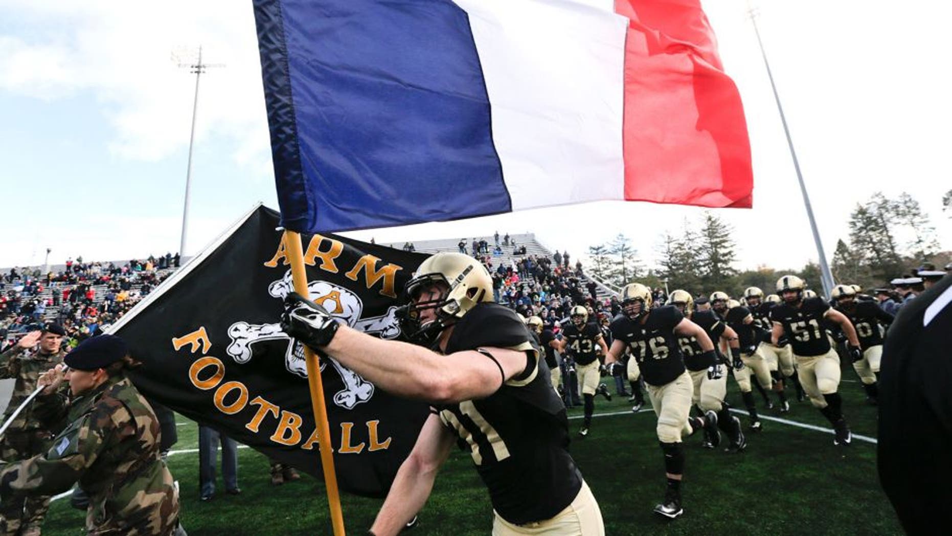 Army defensive back Caleb McNeill carries the flag of France onto the field before an NCAA college football game against Tulane, Saturday, Nov. 14, 2015, in West Point, N.Y. (AP Photo/Mike Groll)
