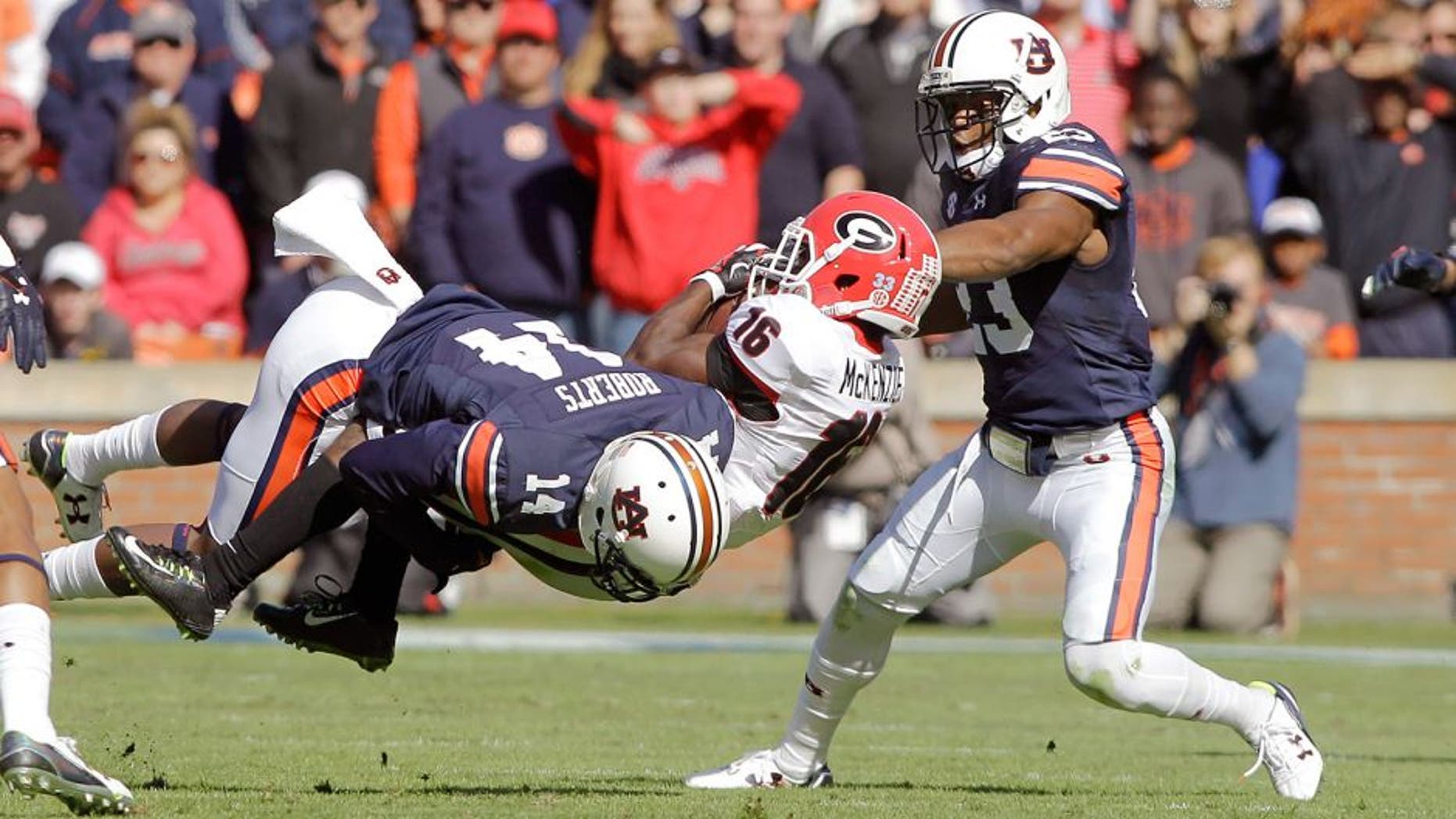 Nov 14, 2015; Auburn, AL, USA; Georgia Bulldogs receiver Isaiah McKenzie (16) is tackled by Auburn Tigers defensive backs Stephen Roberts (14) and Johnathan Ford (23) during the second quarter at Jordan Hare Stadium. Mandatory Credit: John Reed-USA TODAY Sports
