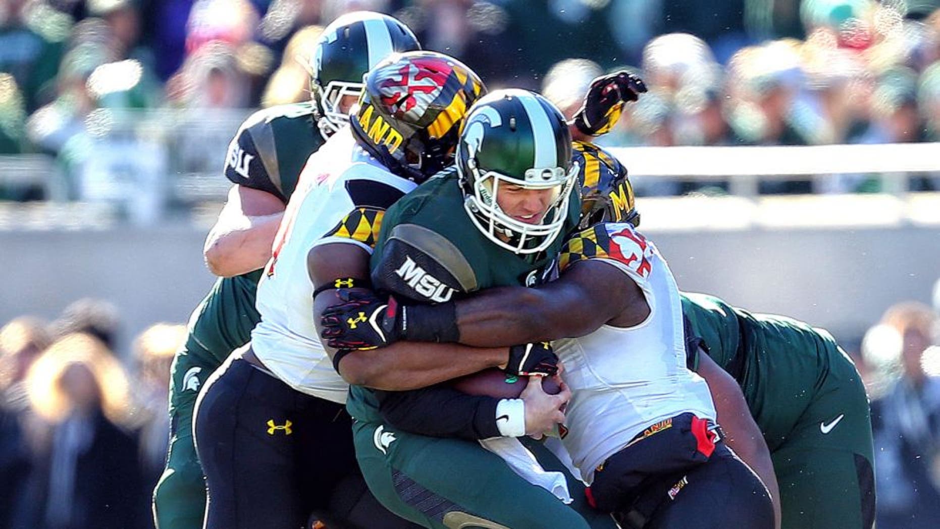 Nov 14, 2015; East Lansing, MI, USA; Michigan State Spartans quarterback Connor Cook (18) carries the ball against the Maryland Terrapins during the first half at Spartan Stadium. Mandatory Credit: Mike Carter-USA TODAY Sports