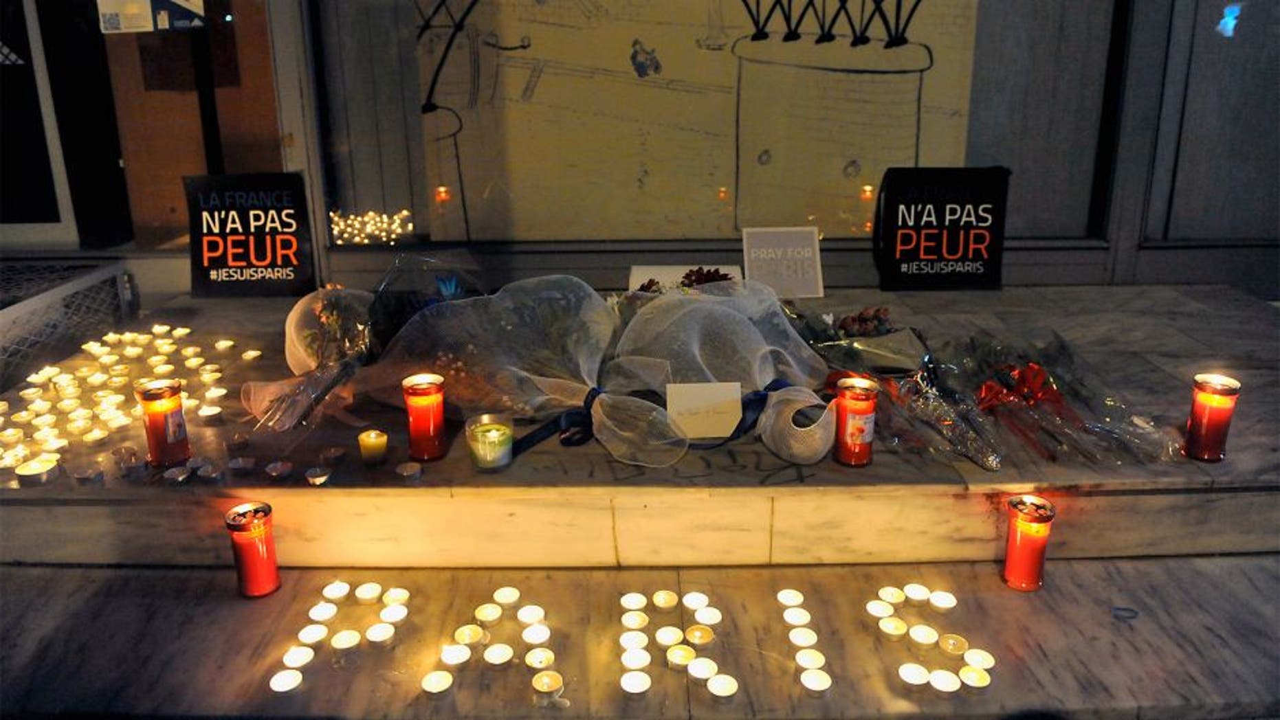 Flowers and candles reading "Paris" are pictured outside the French consulate in Thessaloniki on November 14, 2015, a day after deadly attacks in Paris. Islamic State jihadists claimed a series of coordinated attacks by gunmen and suicide bombers in Paris that killed at least 128 people in scenes of carnage at a concert hall, restaurants and the national stadium. The placards read "France is not afraid". AFP PHOTO / Sakis Mitrolidis (Photo credit should read SAKIS MITROLIDIS/AFP/Getty Images)