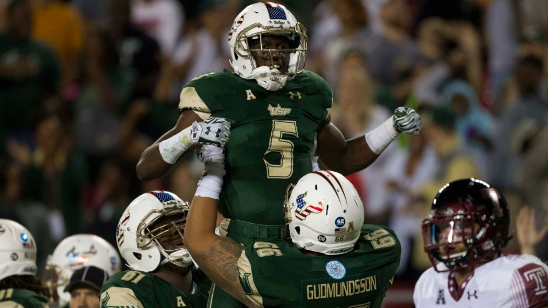 Nov 14, 2015; Tampa, FL, USA; South Florida Bulls running back Marlon Mack (5) celebrates with offensive lineman Dominique Threatt (61) and offensive lineman Brynjar Gudmundsson (66) after scoring a touchdown in the second quarter against the Temple Owls at Raymond James Stadium. Mandatory Credit: Logan Bowles-USA TODAY Sports