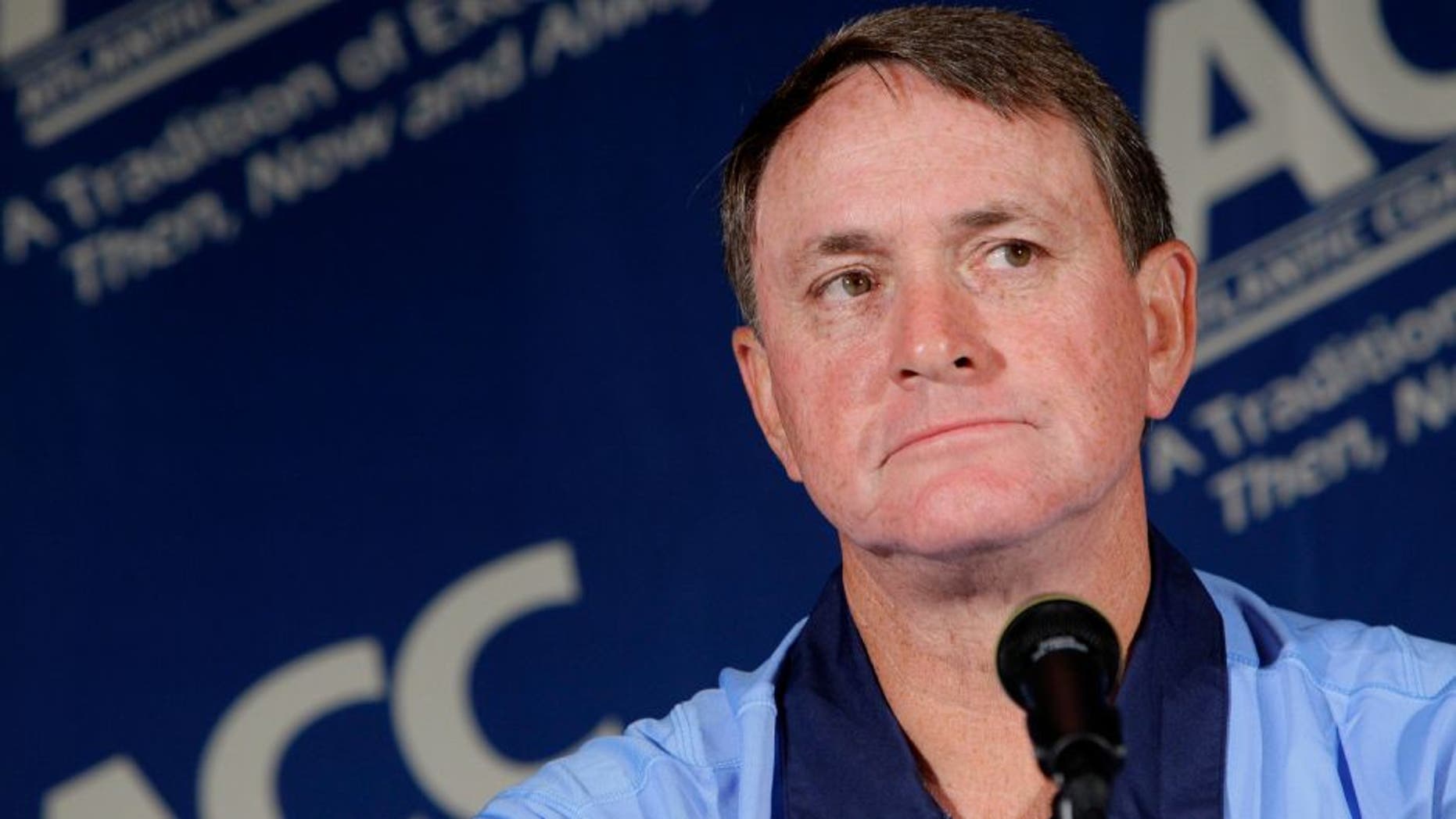 FILE - In this July 25, 2011 file photo, North Carolina coach Butch Davis pauses during interviews at the Atlantic Coast Conference Football Kickoff in Pinehurst, N.C. Davis was hired Monday, Nov. 14, 2016, as the new coach at FIU. (AP Photo/Gerry Broome, File)
