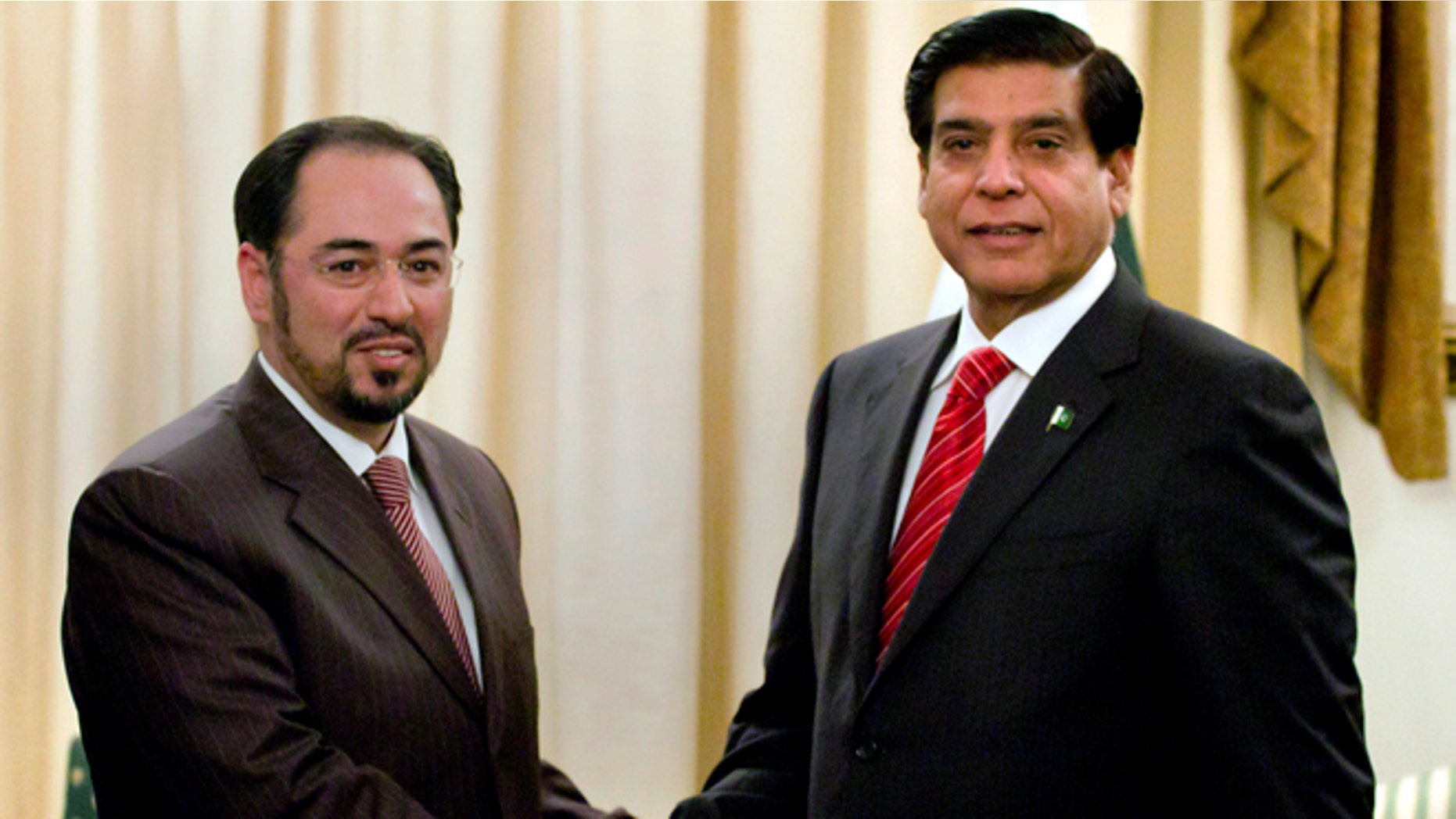 Nov. 12, 2012: Salahuddin Rabbani, left, head of Afghanistan High Peace Council, shakes hand with Pakistan's Prime Minister Raja Pervaiz Ashraf, for the benefit of the media prior to their meeting in Islamabad, Pakistan.