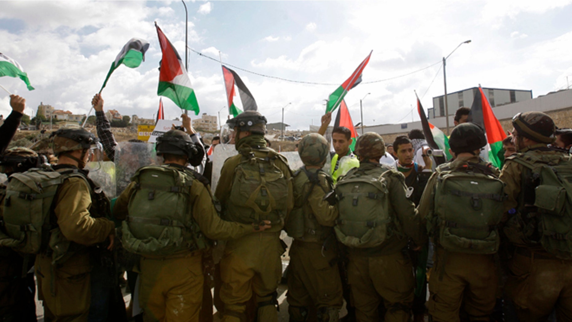 Nov. 14, 2012: Palestinians, foreign and Israeli activists stand in front of Israeli soldiers as they try to block a road near the West Bank town of Bethlehem, as part of a demonstration in support of the Palestinian statehood petition at the U.N. General Assembly.