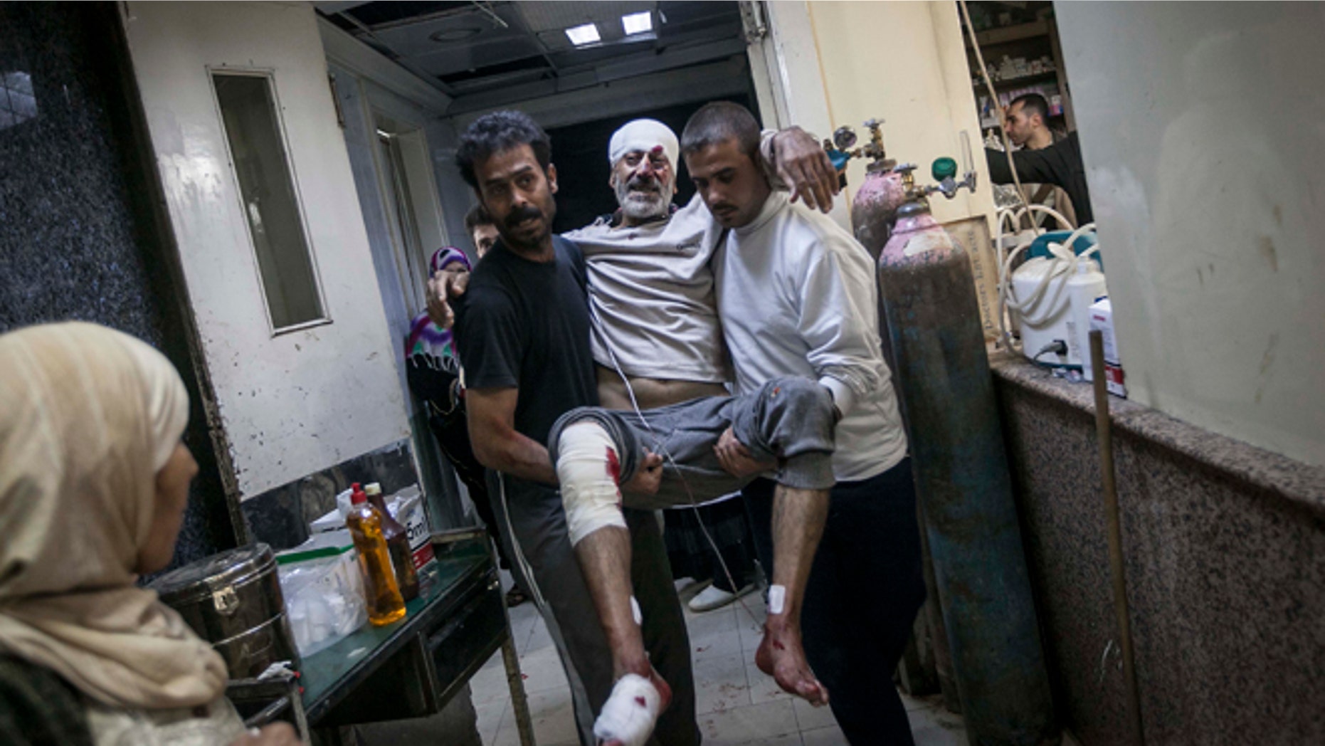 Nov. 13, 2012: A Syrian man is carried in the arms of his relatives at a hospital after he was injured by a mortar shell explosion in the Bab Al-Nayrab neighborhood of Aleppo, Syria.