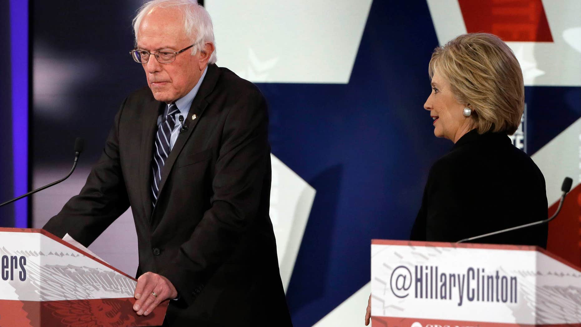 Nov. 14, 2015: Hillary Rodham Clinton, right, walks by Bernie Sanders during a commercial break at a Democratic presidential primary debate in Des Moines, Iowa.