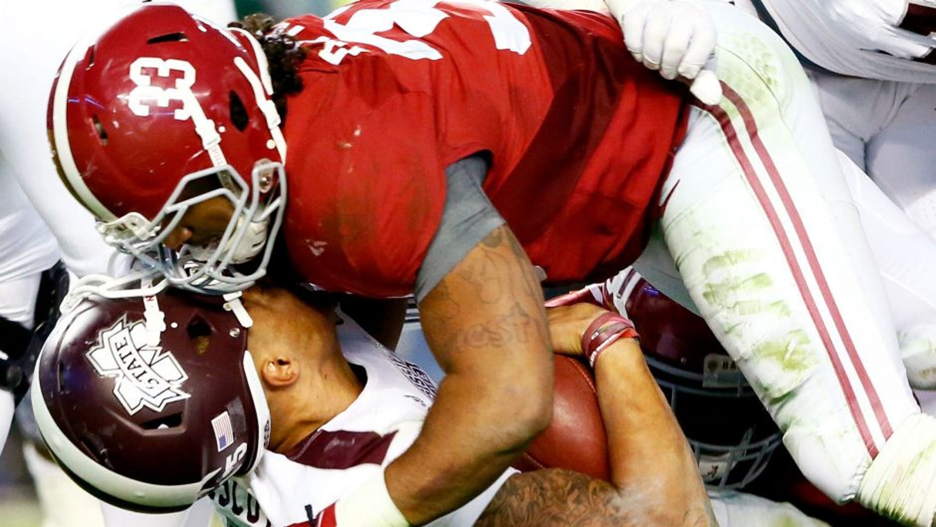 Dak Prescott #15 of the Mississippi State Bulldogs loses his helmet as he is tackled by Trey DePriest #33 of the Alabama Crimson Tide at Bryant-Denny Stadium on November 15, 2014 in Tuscaloosa, Alabama. (Photo by Kevin C. Cox/Getty Images)