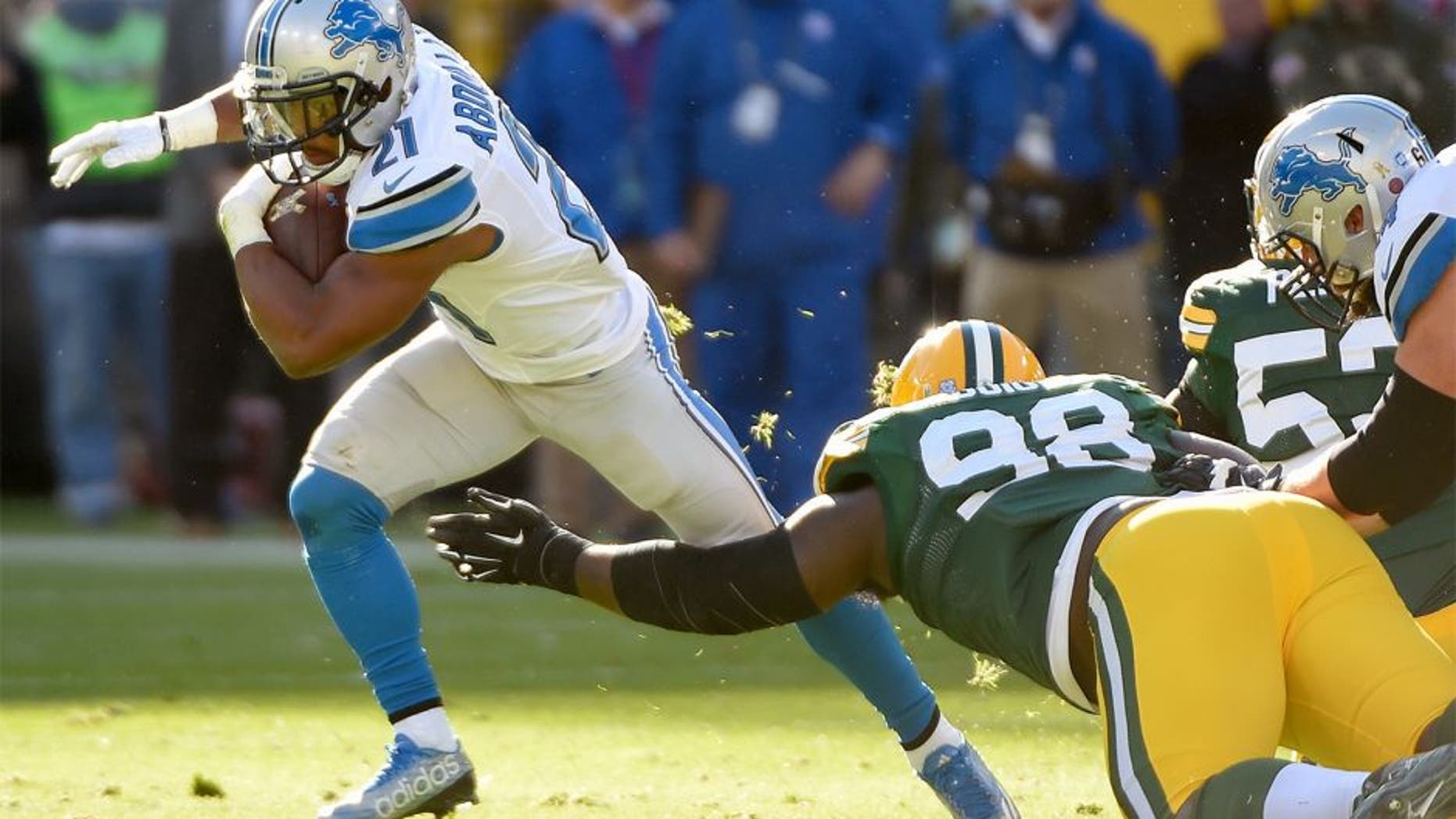 Nov 15, 2015; Green Bay, WI, USA; Detroit Lions running back Ameer Abdullah (21) tries to avoid a tackle by Green Bay Packers defensive tackle Letroy Guion (98) in the second quarter at Lambeau Field. Mandatory Credit: Benny Sieu-USA TODAY Sports