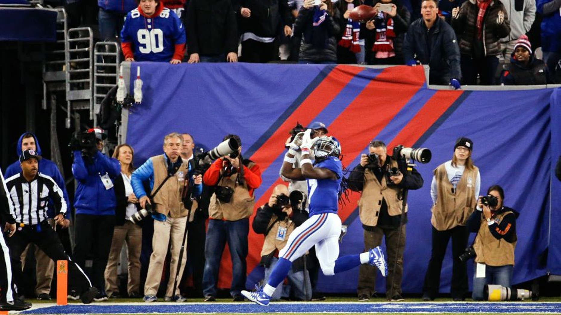 Fans watch as New York Giants wide receiver Dwayne Harris (17) waits for the ball on a touchdown reception during the first half of an NFL football game against the New England Patriots on Sunday, Nov. 15, 2015, in East Rutherford, N.J. (AP Photo/Julio Cortez)