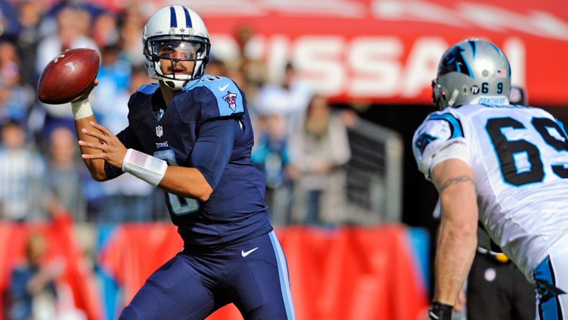 Nov 15, 2015; Nashville, TN, USA; Tennessee Titans quarterback Marcus Mariota (8) rolls out of the pocket chased by Carolina Panthers defensive end Jared Allen (69) during the first half at Nissan Stadium. Mandatory Credit: Christopher Hanewinckel-USA TODAY Sports