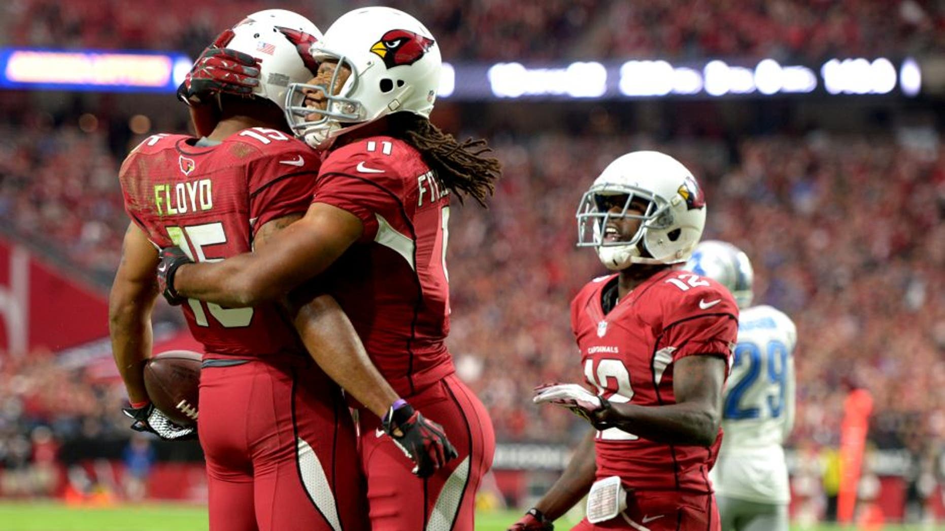 Nov 16, 2014; Glendale, AZ, USA; Arizona Cardinals receiver Michael Floyd (15) celebrates with receivers Larry Fitzgerald (11) and John Brown (12) after scoring on a 12-yard touchdown pass in the first quarter against the Detroit Lions at University of Phoenix Stadium. Mandatory Credit: Kirby Lee-USA TODAY Sports