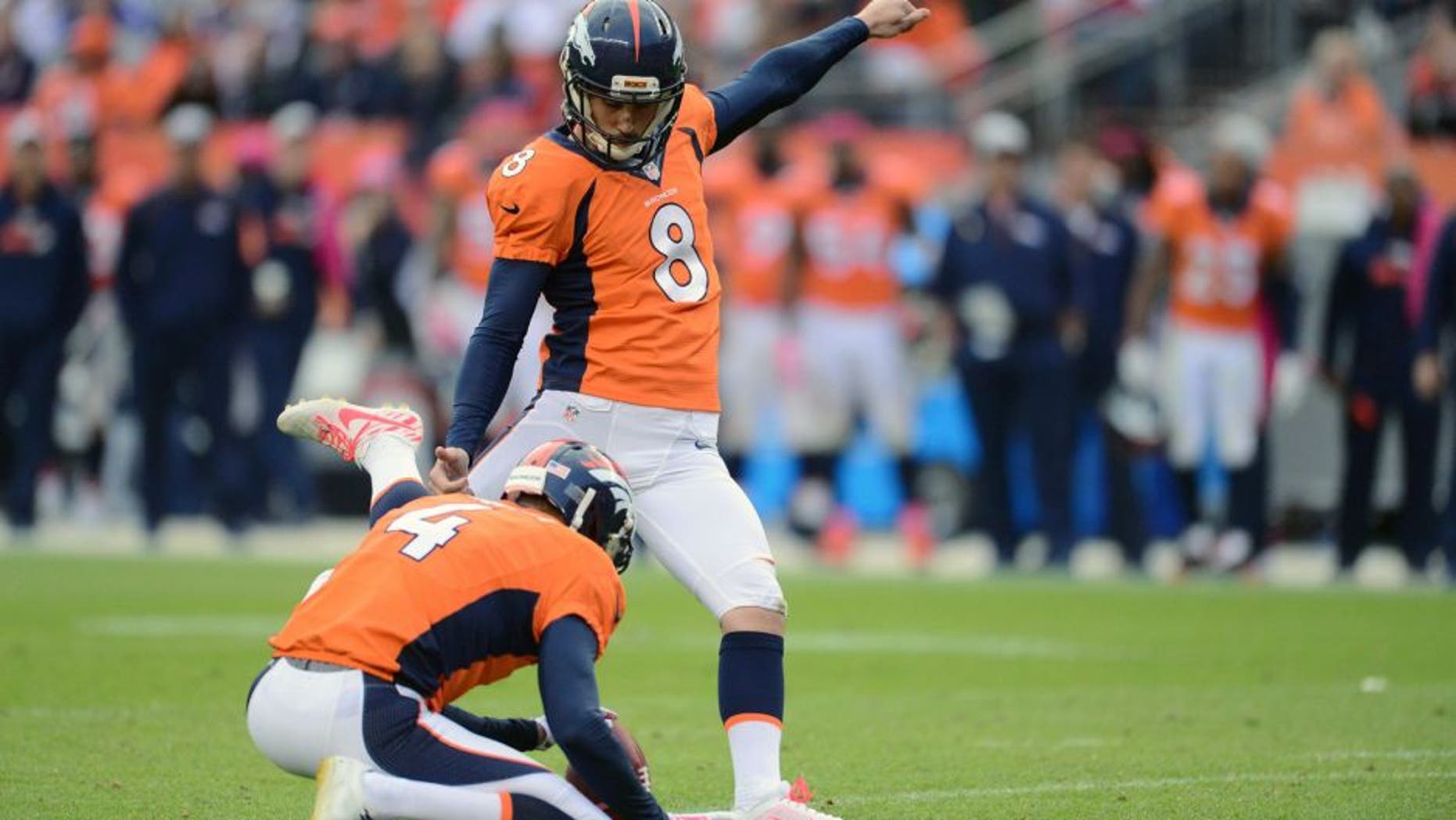 Oct 4, 2015; Denver, CO, USA; Denver Broncos kicker Brandon McManus (8) kicks the go ahead field goal as punter Britton Colquitt (4) holds late in the fourth quarter against the Minnesota Vikings at Sports Authority Field at Mile High. The Broncos defeated the Vikings 23-20. Mandatory Credit: Ron Chenoy-USA TODAY Sports