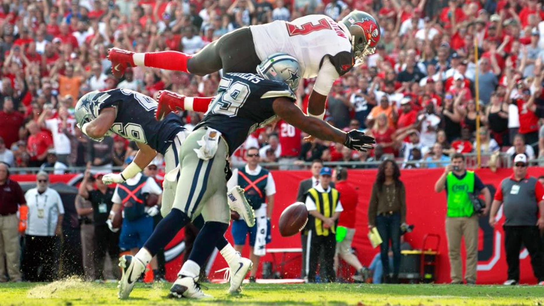 Nov 15, 2015; Tampa, FL, USA; Tampa Bay Buccaneers quarterback Jameis Winston (3) jumps over Dallas Cowboys middle linebacker Anthony Hitchens (59) and fumbles the ball during the second half at Raymond James Stadium. Mandatory Credit: Kim Klement-USA TODAY Sports