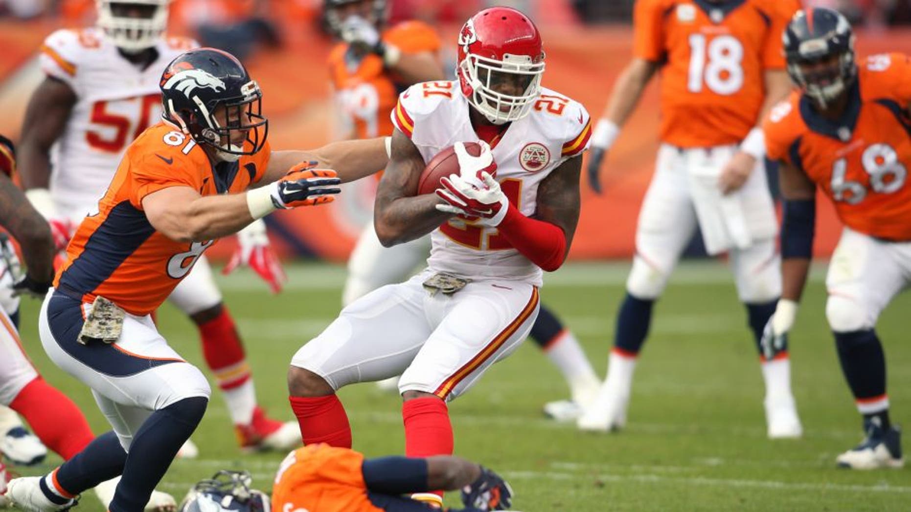 Nov 15, 2015; Denver, CO, USA; Kansas City Chiefs cornerback Sean Smith (21) attempts to avoid being tackled by Denver Broncos tight end Owen Daniels (81) and wide receiver Emmanuel Sanders (10) after intercepting a pass throw by Denver Broncos quarterback Peyton Manning (18) during the first half at Sports Authority Field at Mile High. Mandatory Credit: Chris Humphreys-USA TODAY Sports