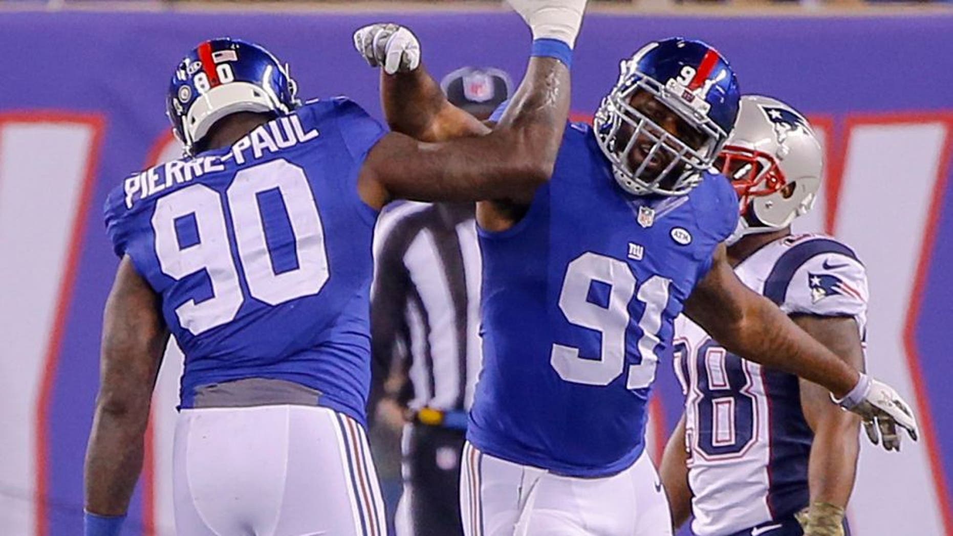 Nov 15, 2015; East Rutherford, NJ, USA; New York Giants defensive end Jason Pierre-Paul (90) celebrates with defensive end Robert Ayers (91) during the fourth quarter against the New England Patriots at MetLife Stadium. Jason Pierre-Paul had to put protection on after hurting his hand by deflecting a pass during the first half. New England Patriots defeat the New York Giants 27-26. Mandatory Credit: Jim O'Connor-USA TODAY Sports
