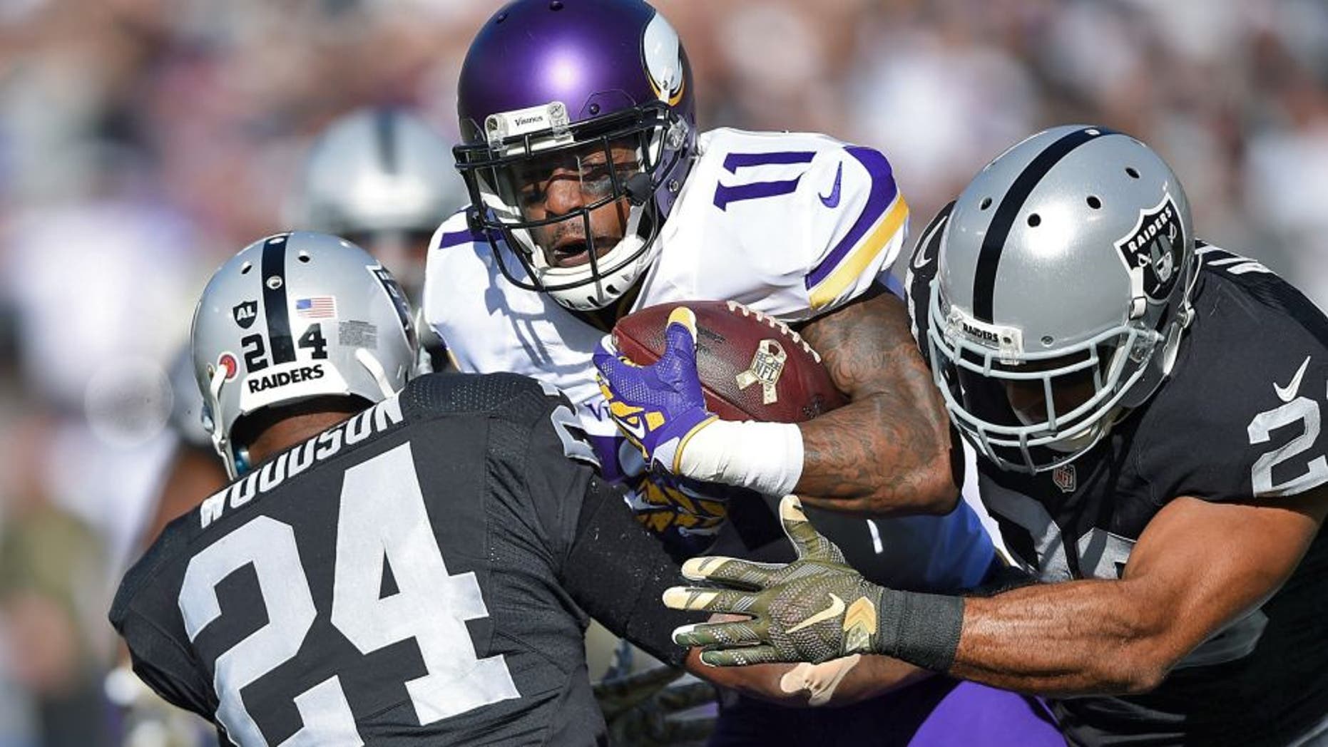 OAKLAND, CA - NOVEMBER 15: Wide receiver Mike Wallace #11 of the Minnesota Vikings is stopped by free safety Charles Woodson #24 of the Oakland Raiders and strong safety Nate Allen #20 of the Oakland Raiders in the first quarter at O.co Coliseum on November 15, 2015 in Oakland, California. (Photo by Thearon W. Henderson/Getty Images)